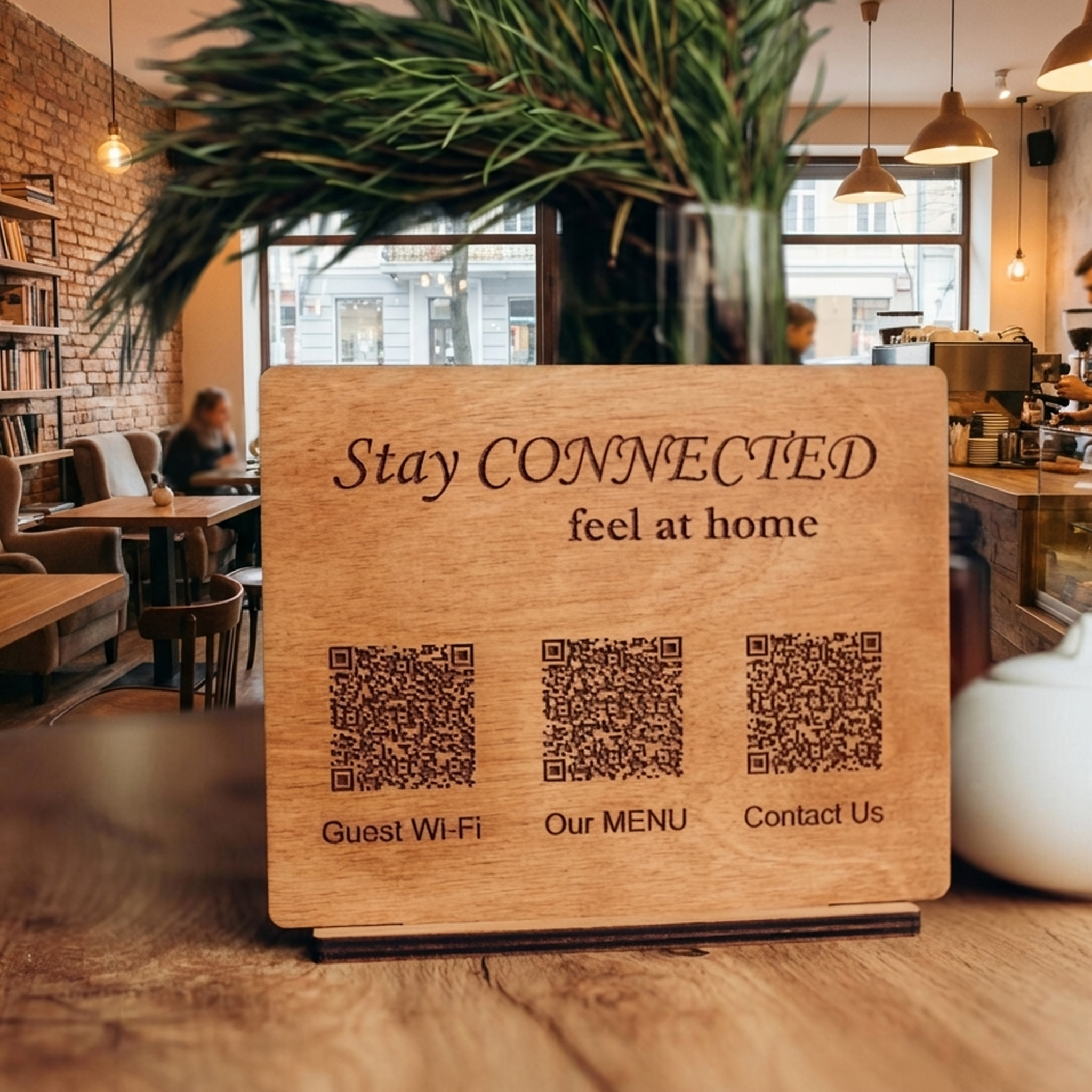 Wooden tabletop sign with multiple QR codes for guest Wi-Fi, menu and contact information displayed in a café setting