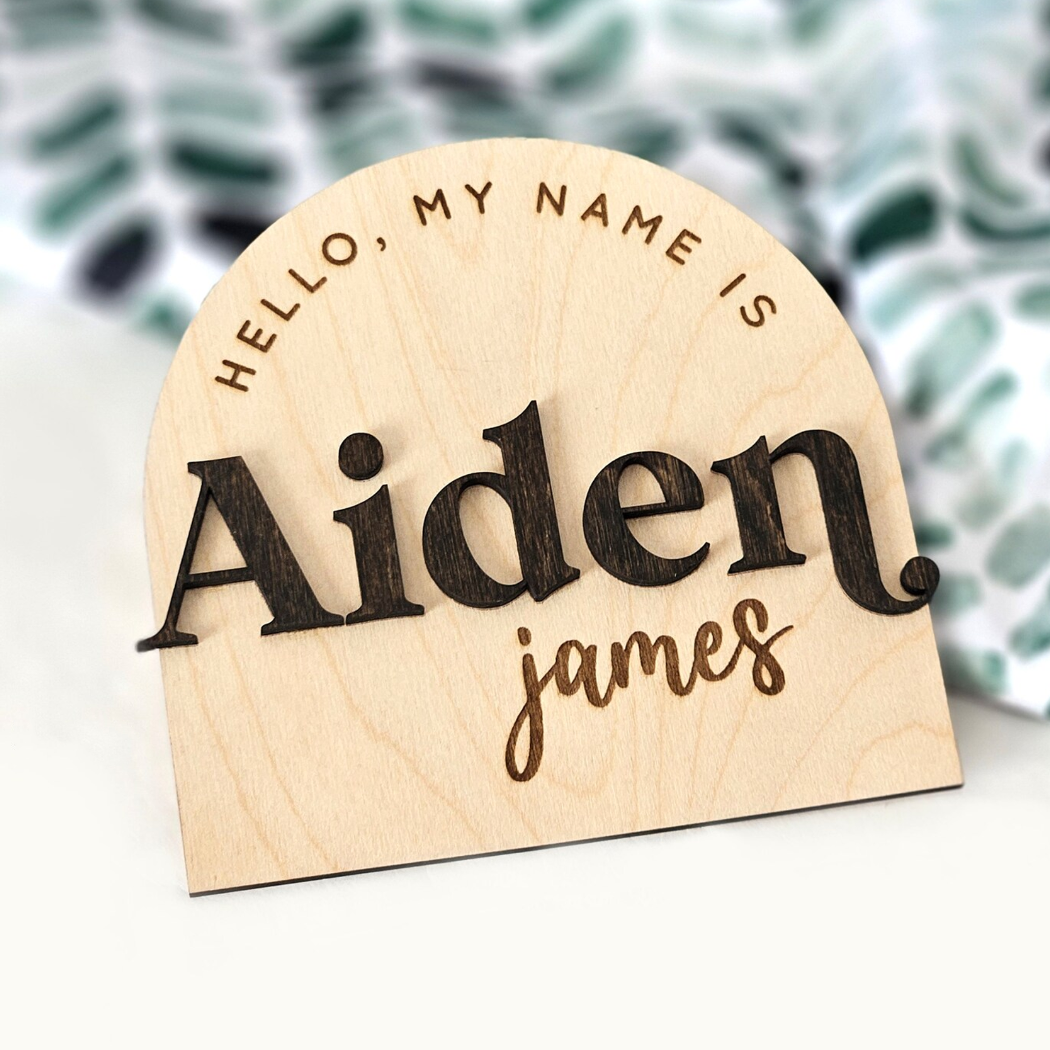Personalised wooden name plaque with layered lettering and engraved text, suitable for nursery or children’s room decor