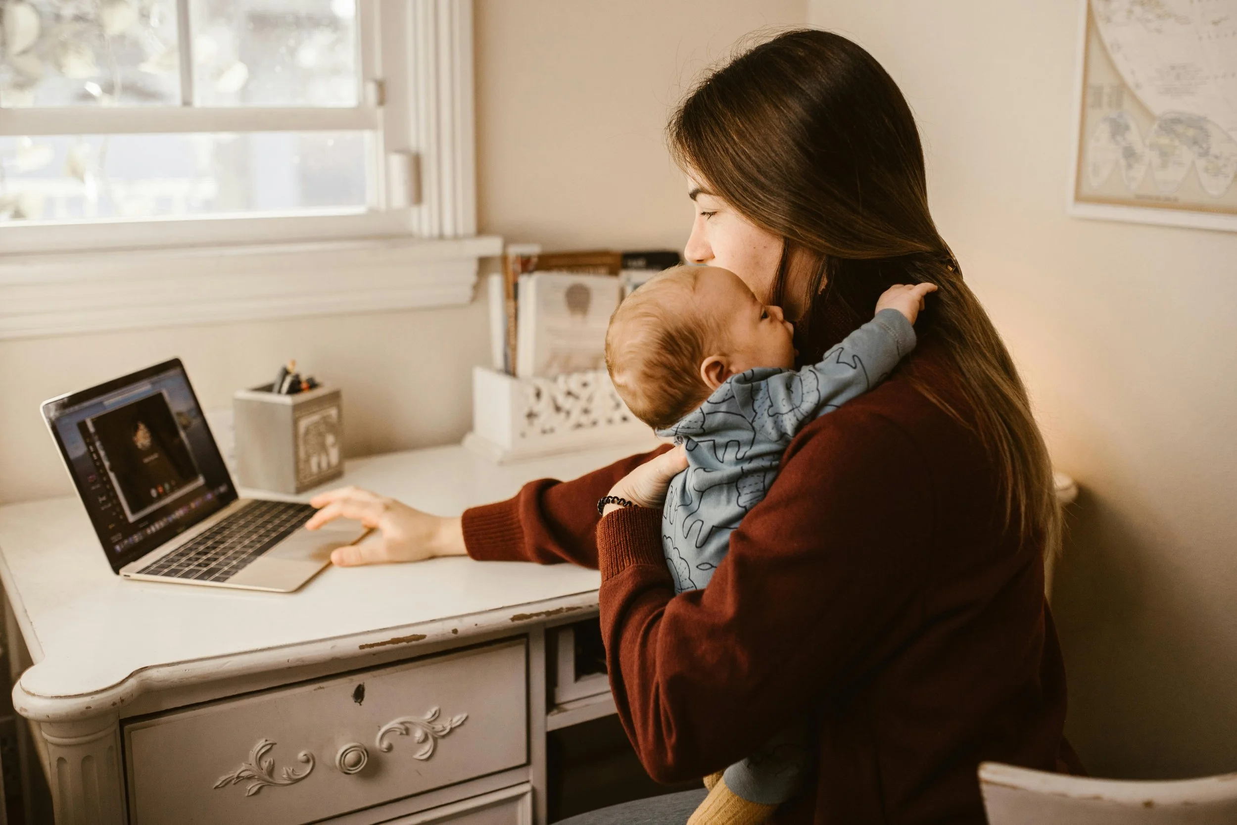 Mom with baby on computer working on the group program for heather boyd infant sleep