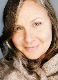 Close-up of a woman with blue eyes and brown hair, smiling softly