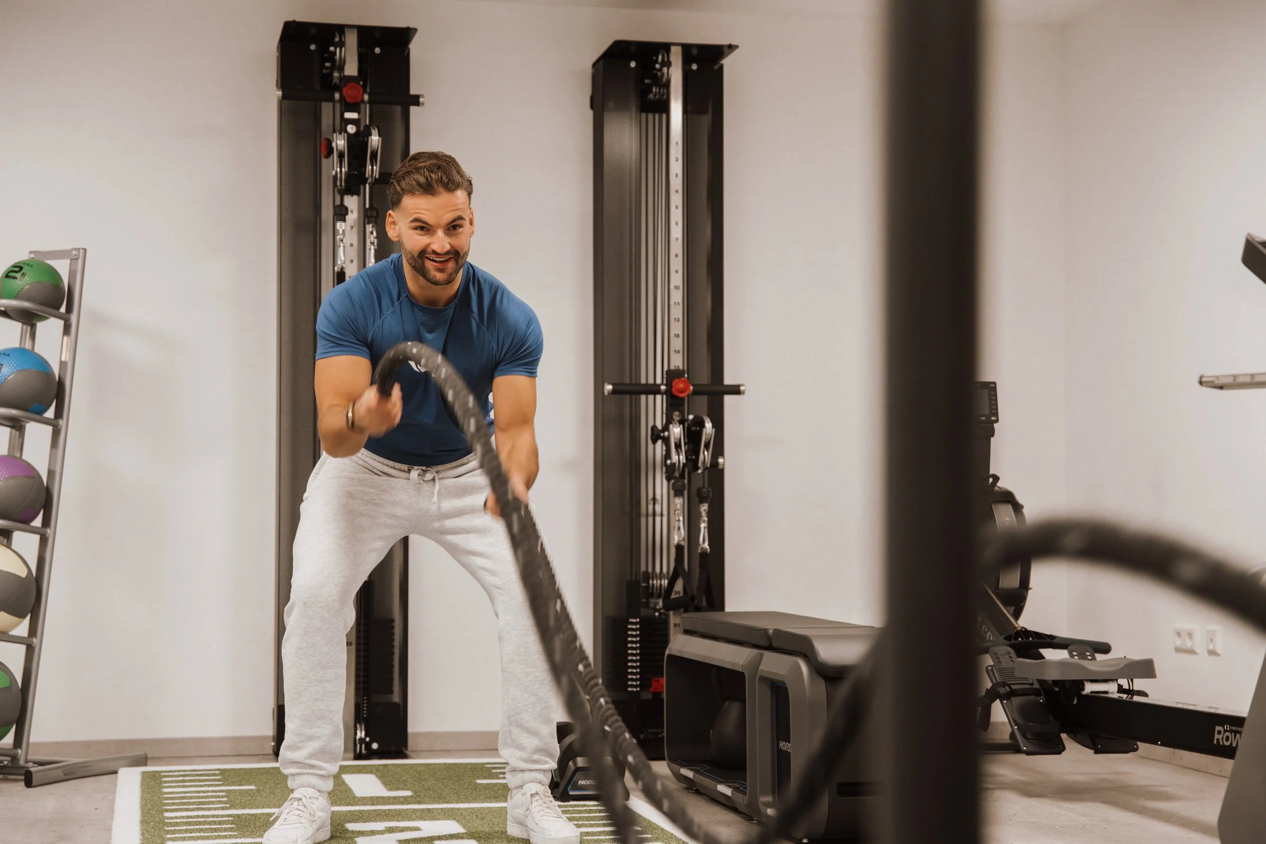 Mann beim Krafttraining mit Seilen im Fitnessstudio.