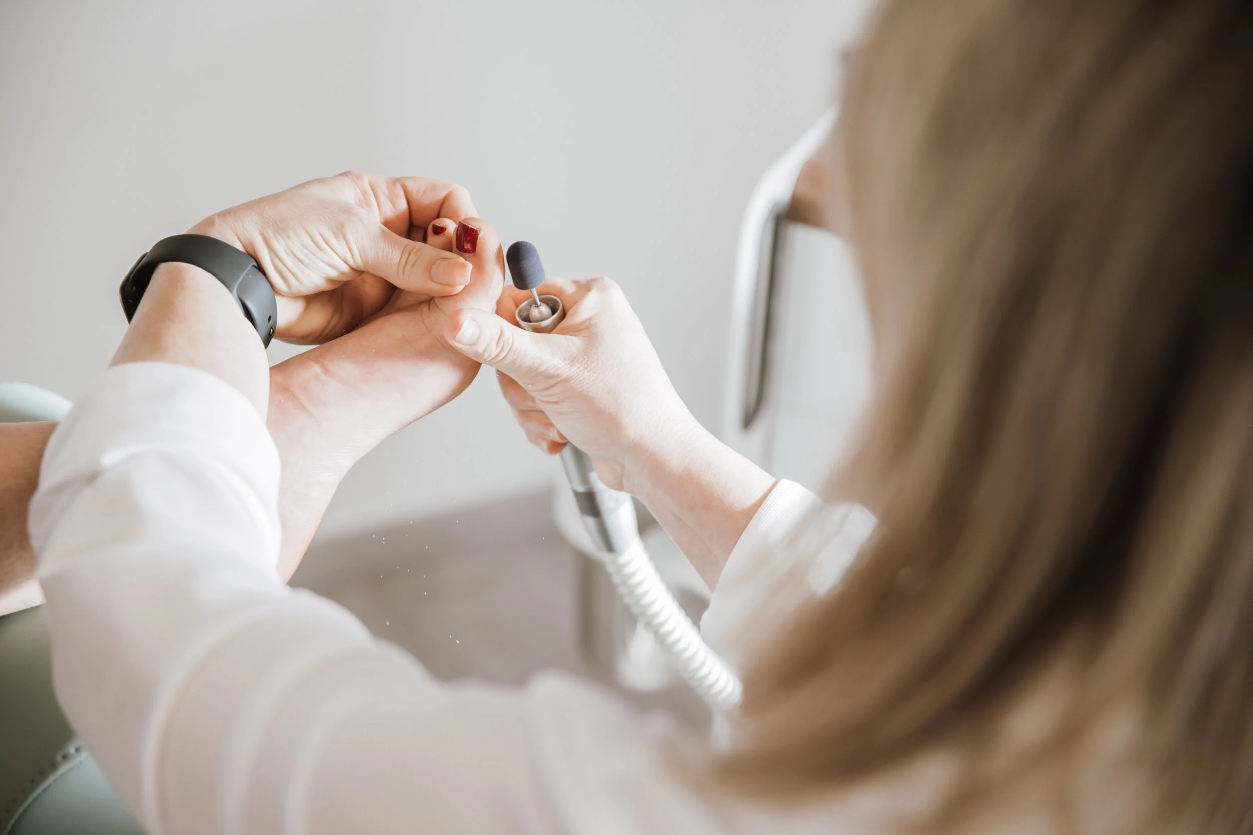Ärztin bei einer Untersuchung eines Patienten mit einem Hörgerät an seinem Ohr.