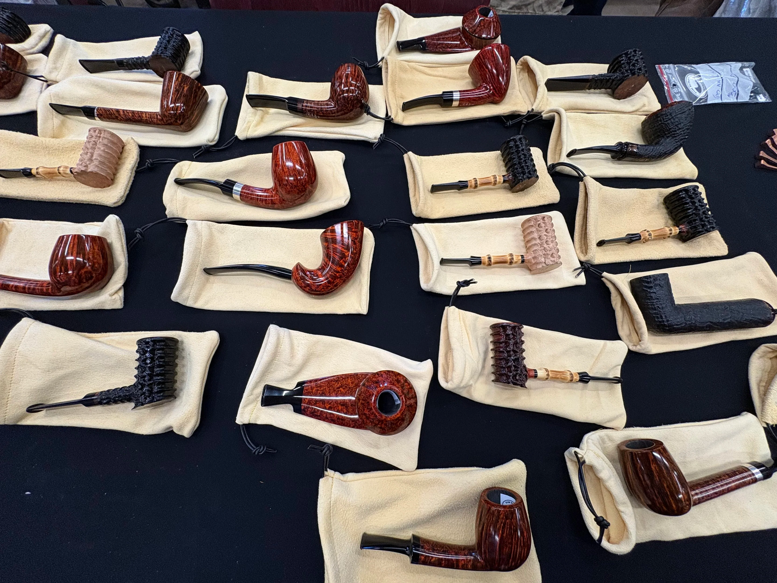 Collection of eltang tobacco pipes displayed on beige cloth pouches.