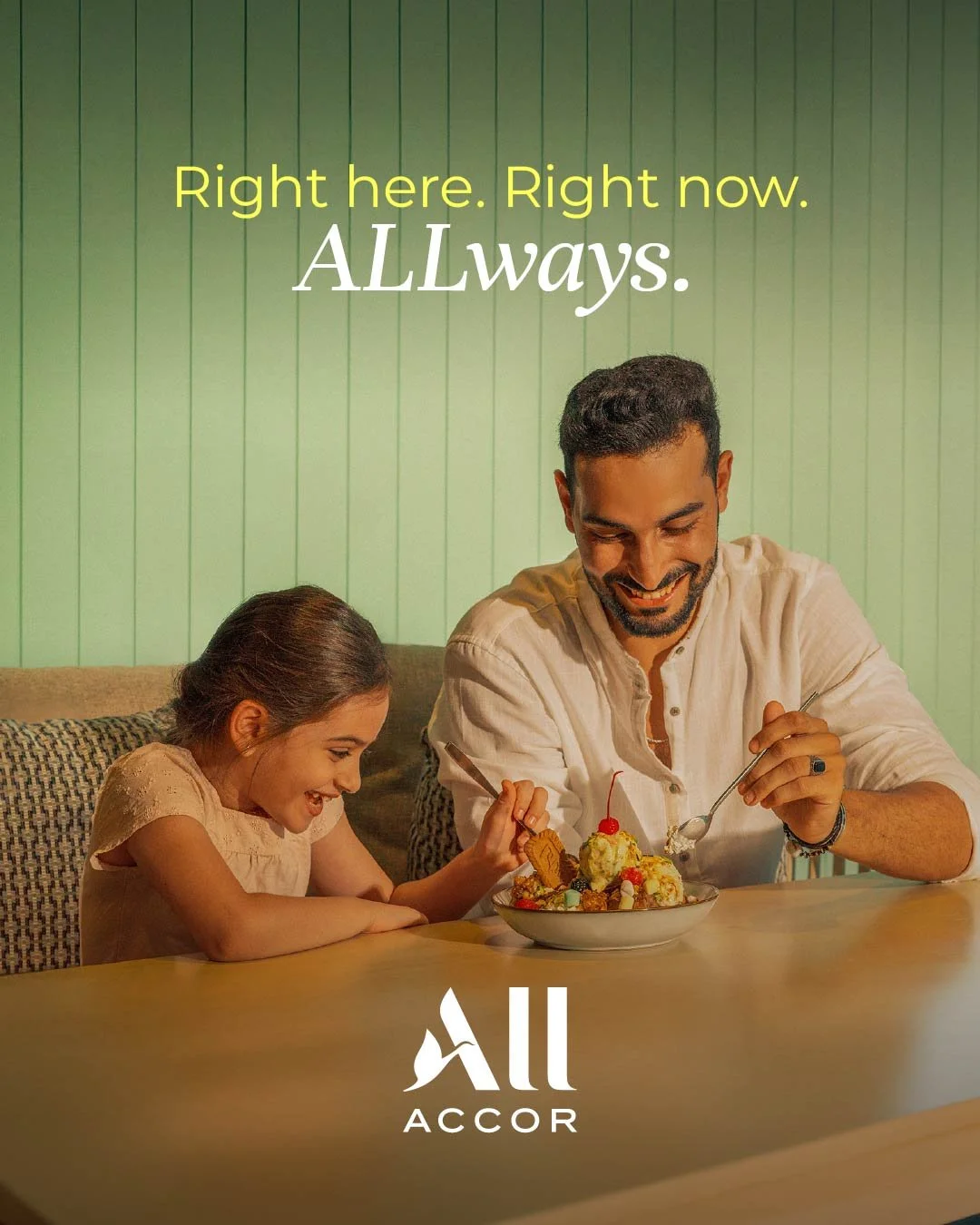 A man and a young girl smiling and sharing a bowl of ice cream at a table, with a green paneled wall in the background. The text says "Right here. Right now. ALLWAYS." and the logo "All ACCOR."