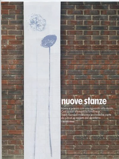 Street art on a brick wall featuring two dandelions and Italian text promoting a literary or cultural event.
