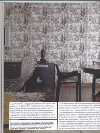 Hotel room with patterned wallpaper, a black chair, a desk with decorative bust and a small device, and a round table, with the word 'hotel' in the top left corner.