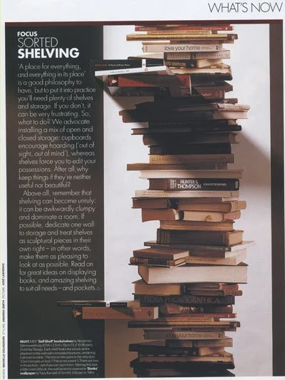 A tall, chaotic stack of books and magazines on a shelf, with a focus on good shelf organization and storage ideas.