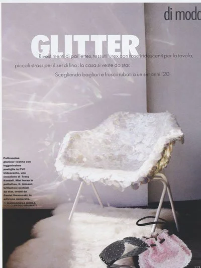 Chic modern chair with fluffy white upholstery in a stylish room, next to a magazine.