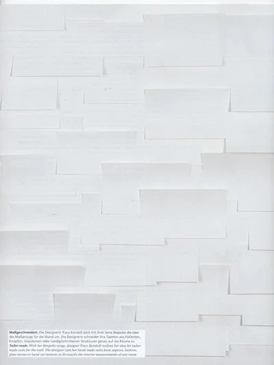 White wall with textured rectangular 3D tile pattern.