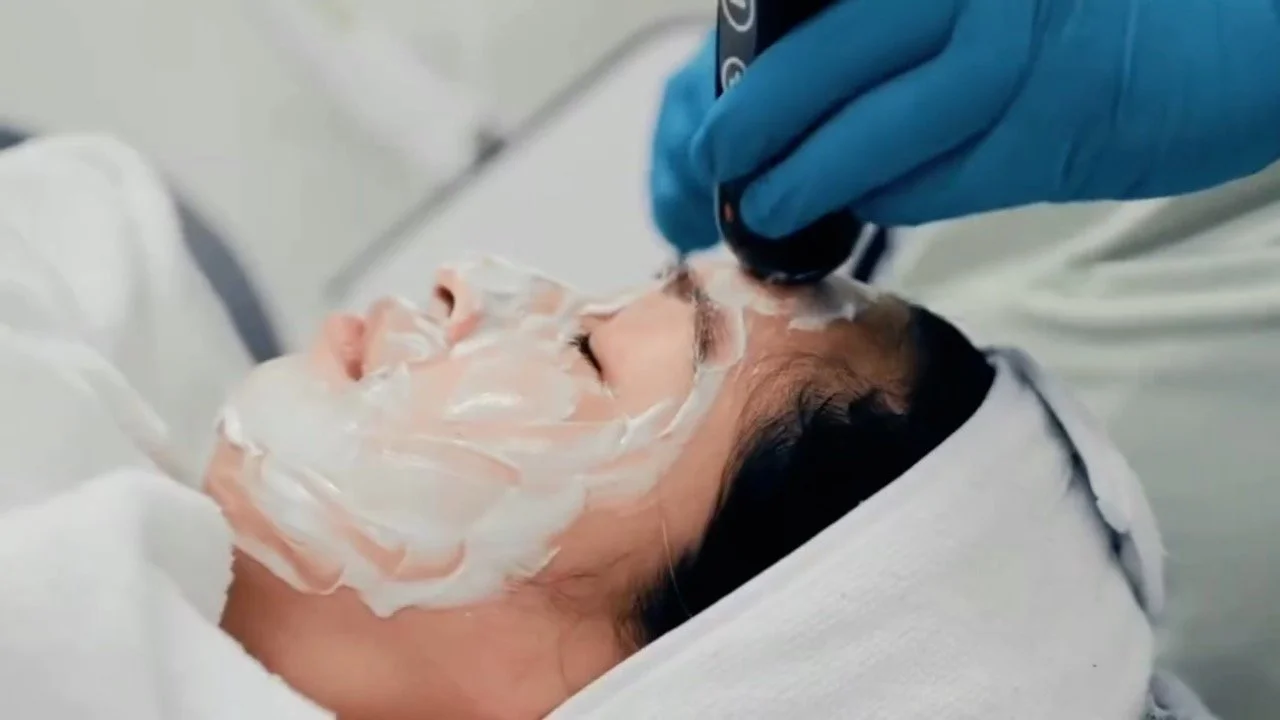 Person receiving a facial treatment with cream applied to face at a spa or clinic