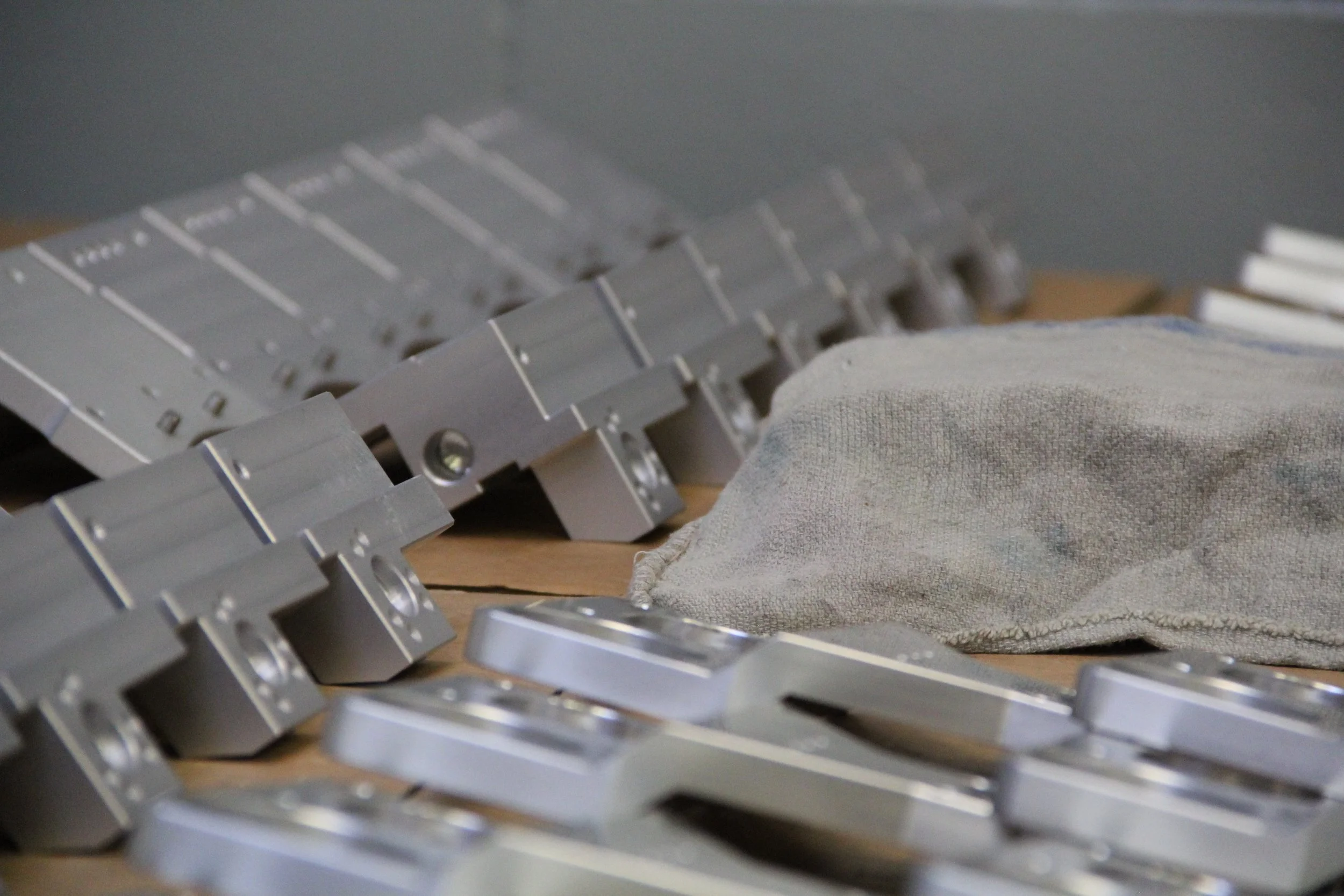 Serie di componenti pronti per il montaggio meccanico adagiati in maniera organizzata sul banco di lavoro.