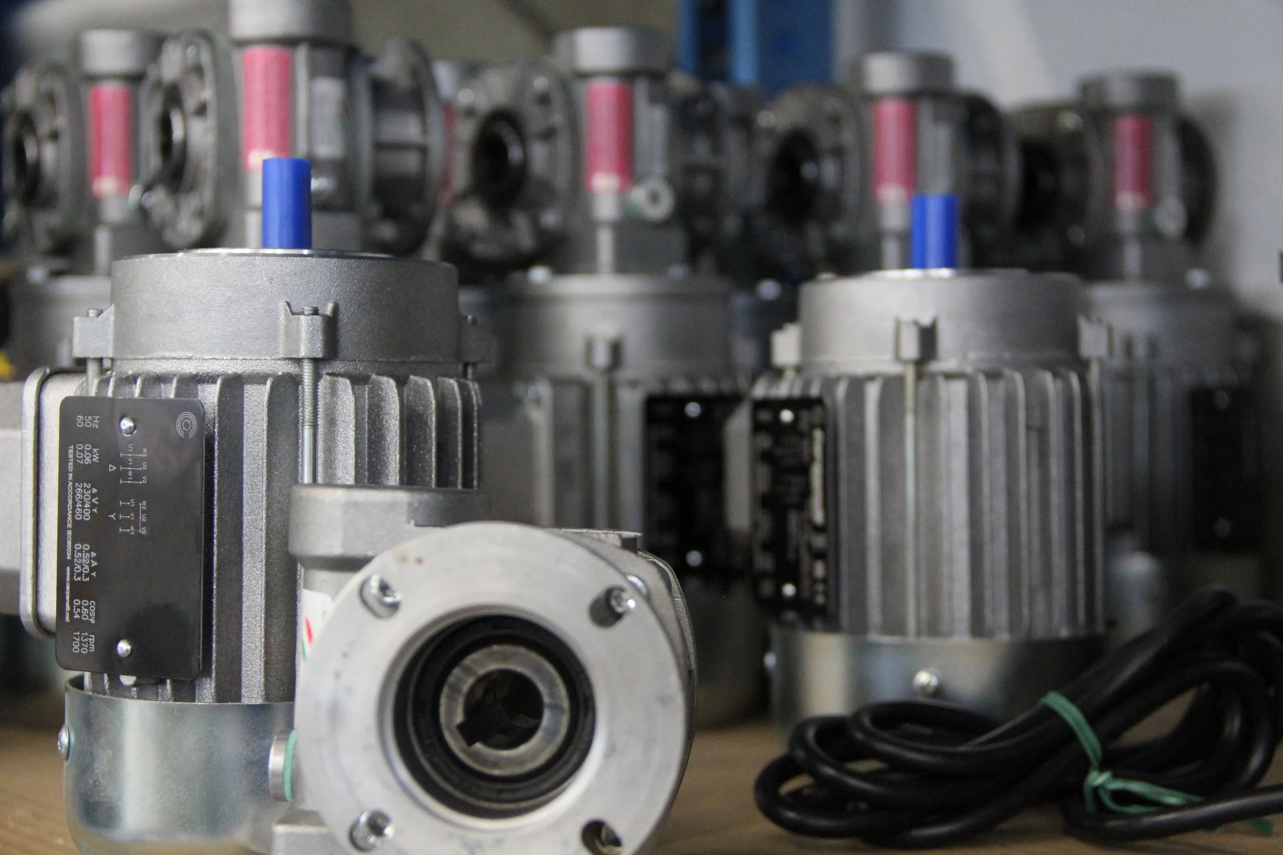 Motori elettrici industriali con cavi appoggiati su un banco di lavoro.