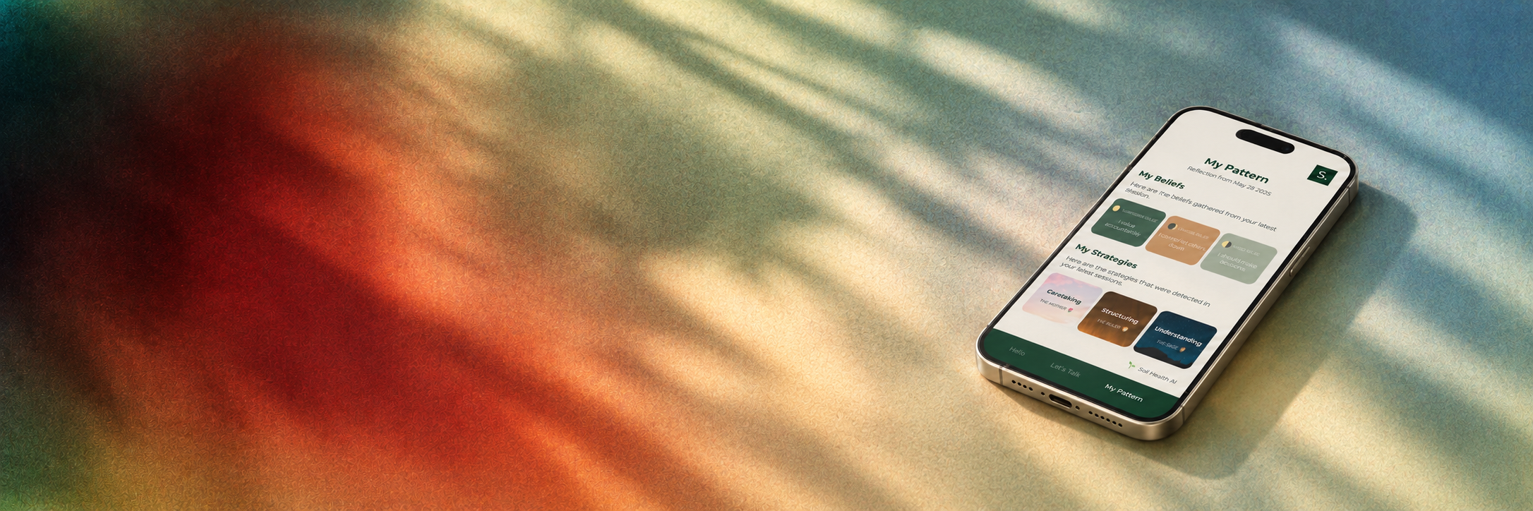 A smartphone lying on a colorful surface with shadows cast across it. The phone screen displays a wellness or self-improvement app with sections labeled "My Beliefs" and "My Strategies".