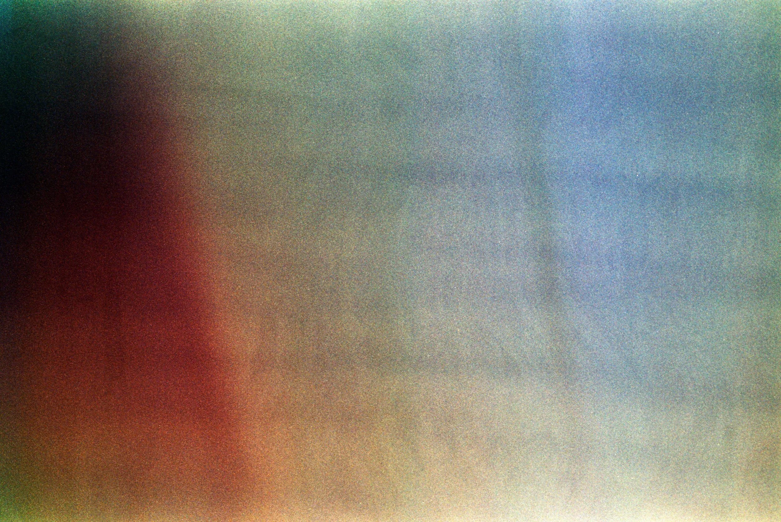 Abstract multicolored gradient with red, green, blue, and yellow hues blending together.