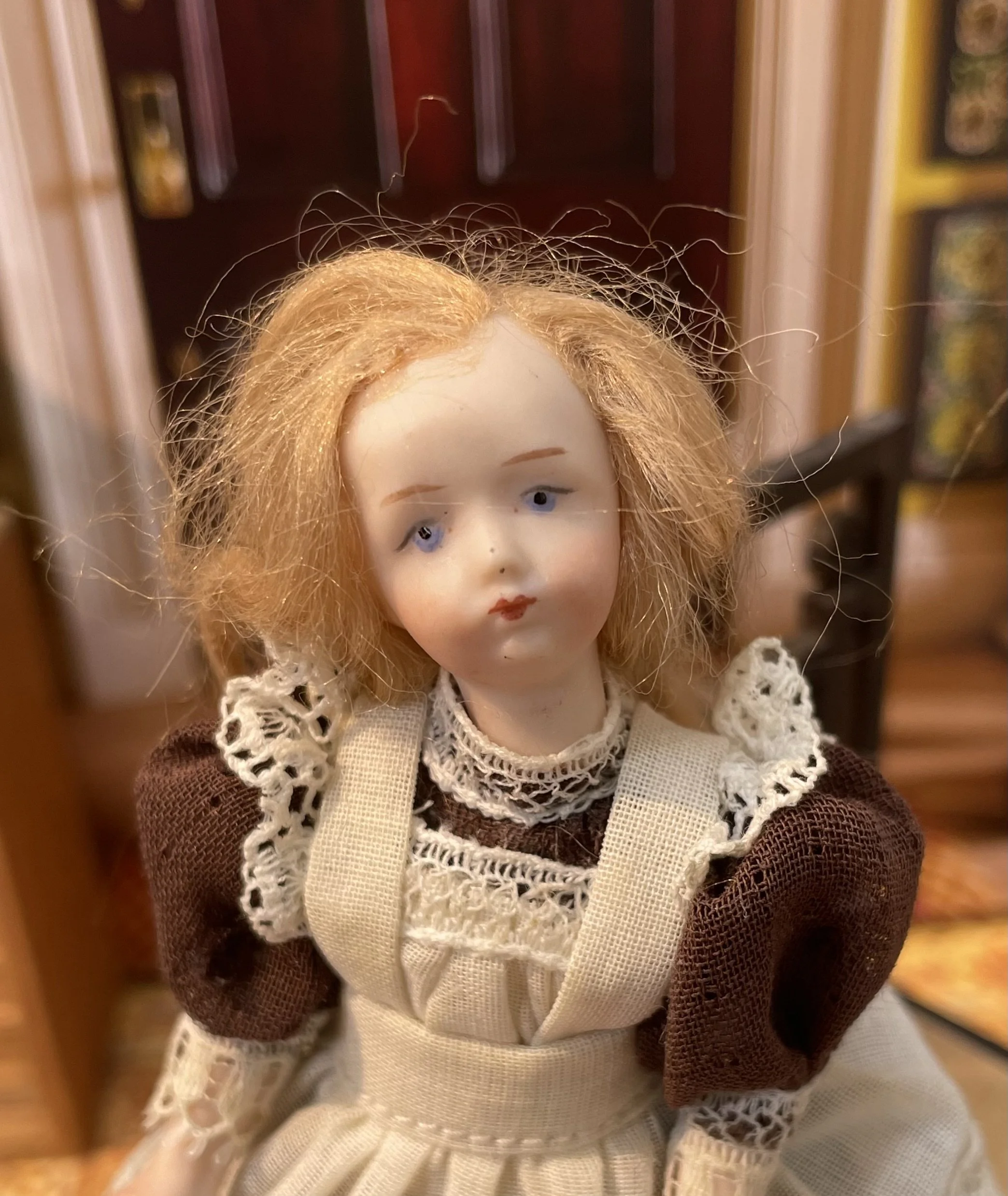 Girl in brown dress with cream apron