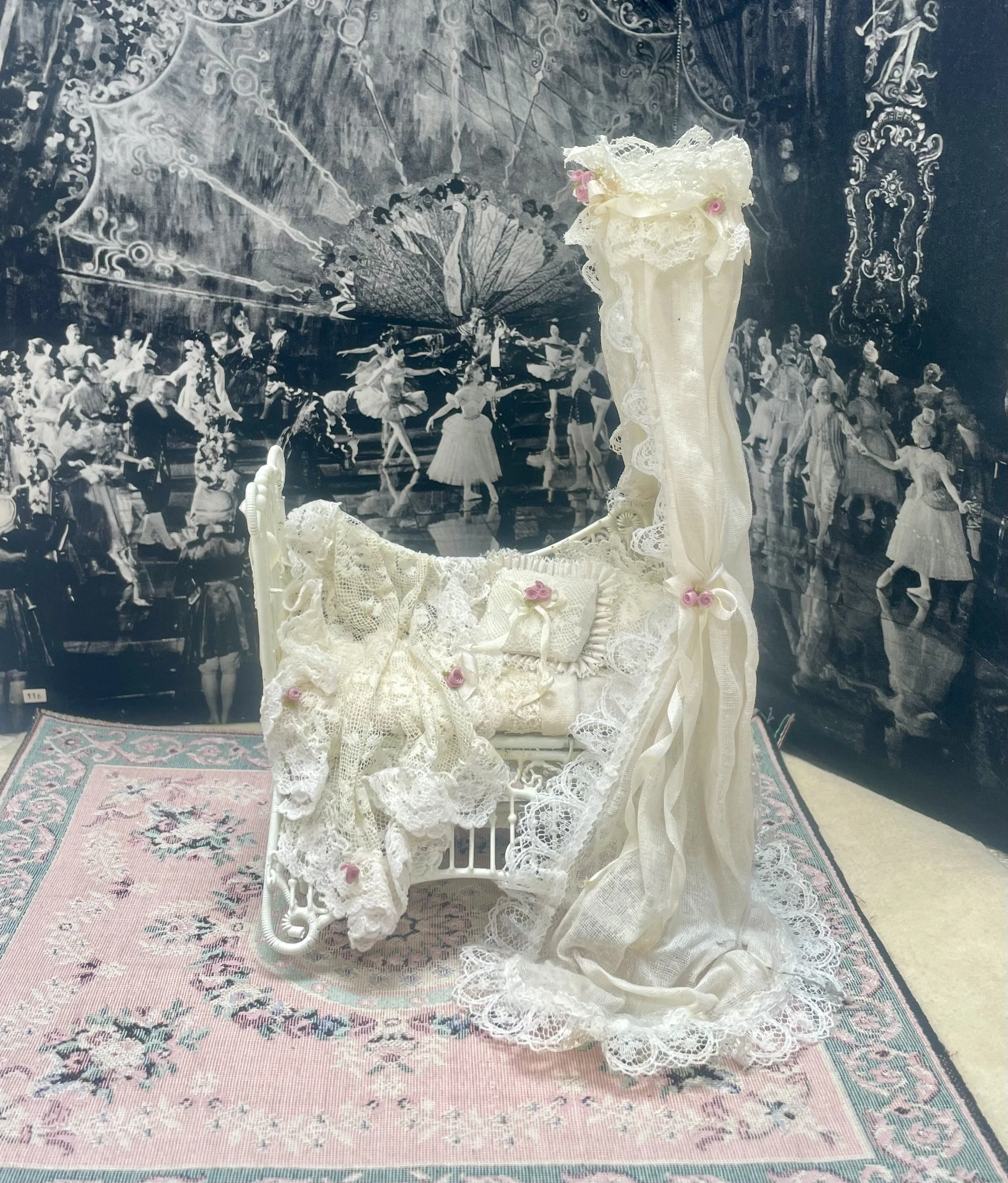 White metal canopied cradle