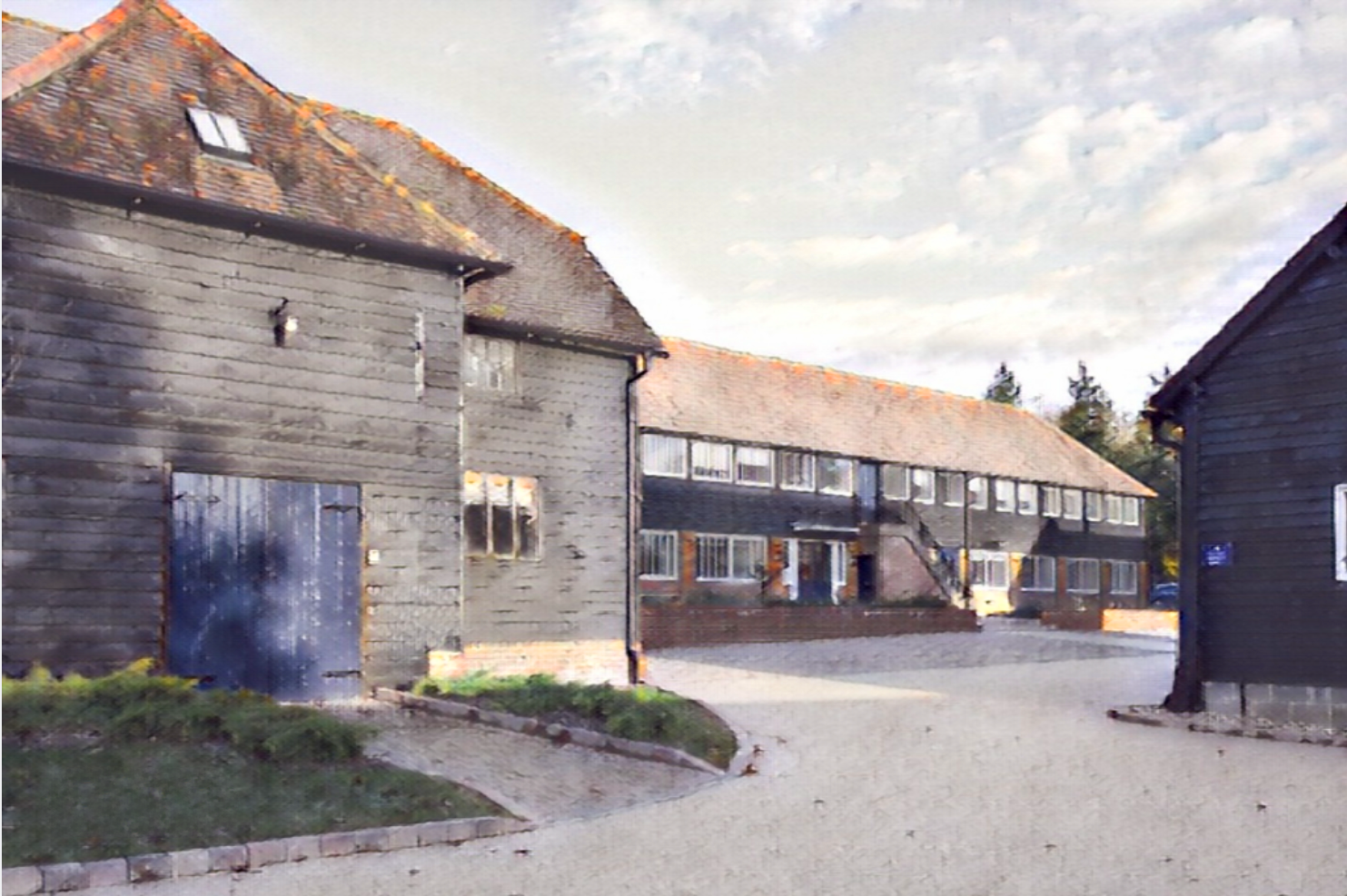 View of traditional wooden buildings with tiled roofs in a small village or town, under a partly cloudy sky.