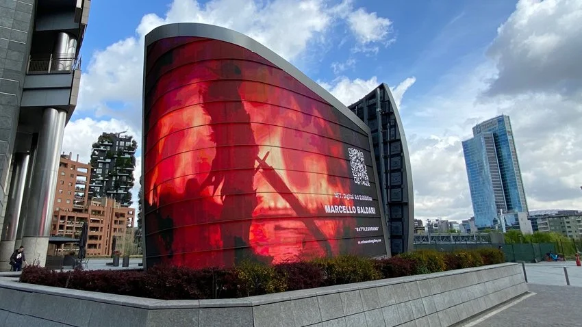 Maxi led wall con opera digitale di Marcello Baldari su una struttura moderna nel centro di Milano, con grattacieli sullo sfondo.