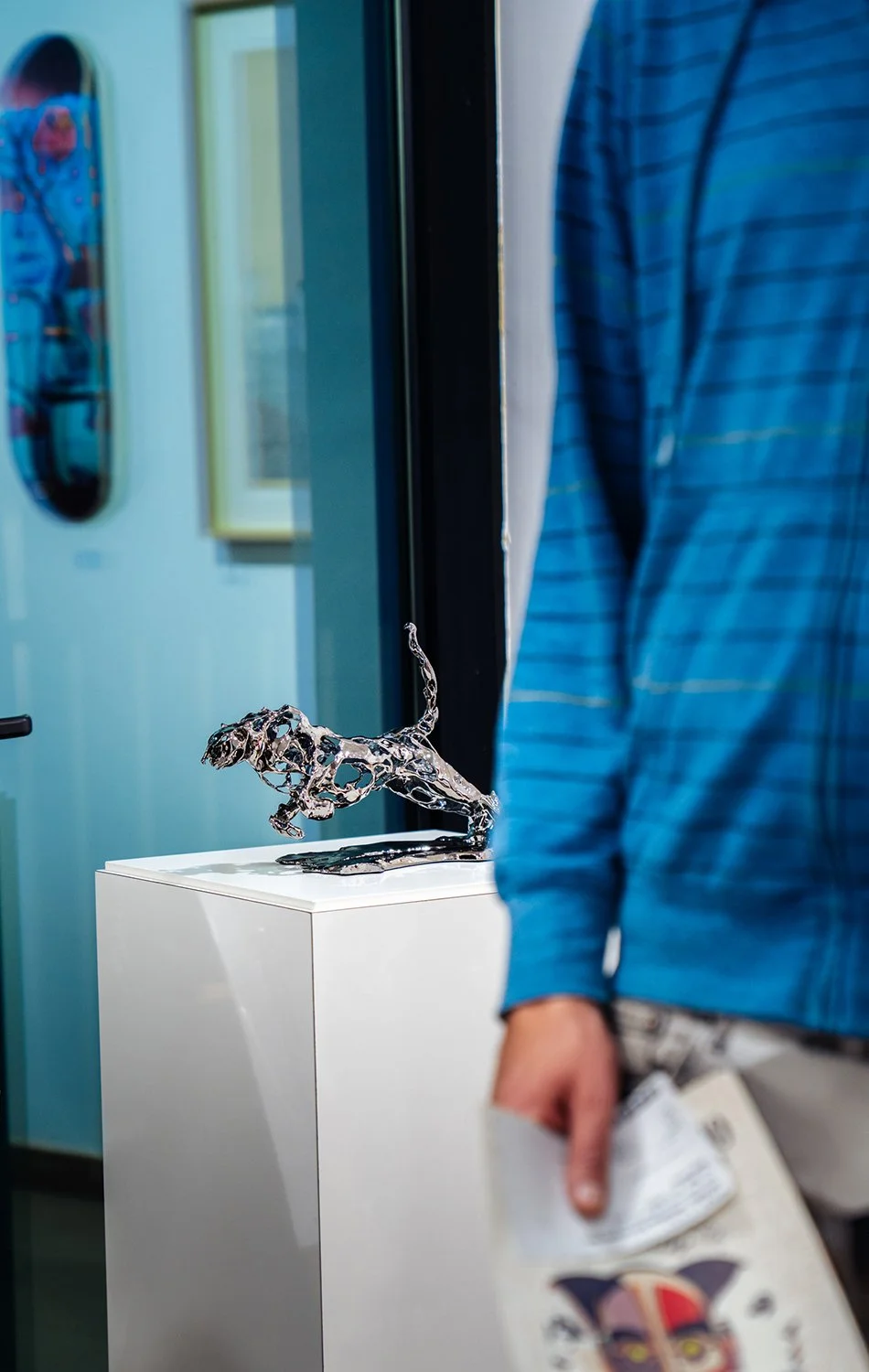 Statua di un ghepardo realizzata in metallo lucido posizionata su un supporto bianco. L'opera digitale si chiama Cheetah e fa parte della collezione SuperPower di Marcello Baldari.