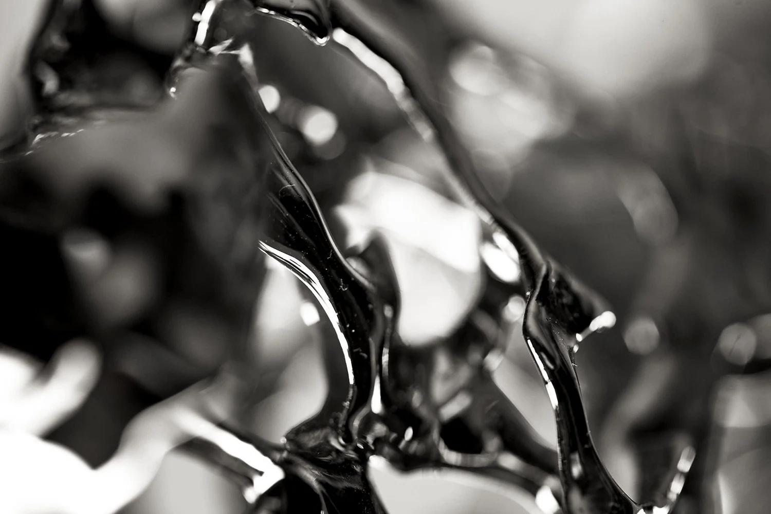 Close-up di materiali cromati con superficie lucida e riflessi, realizzati tramite electroplating.