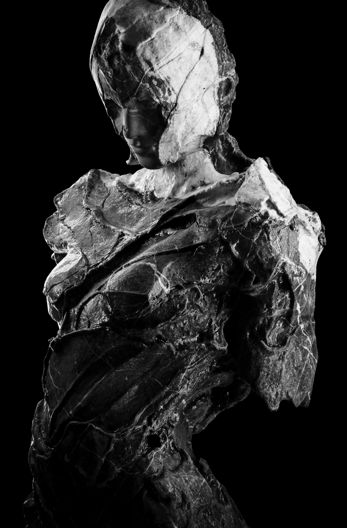 Scultura in marmo di busto femminile, caratterizzata da superfici materiche e frammentazione della forma.