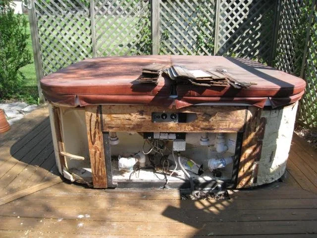 Old outdoor hot tub removal by Millard Junk Removal in Omaha, featuring spa demolition and hauling from a residential deck.