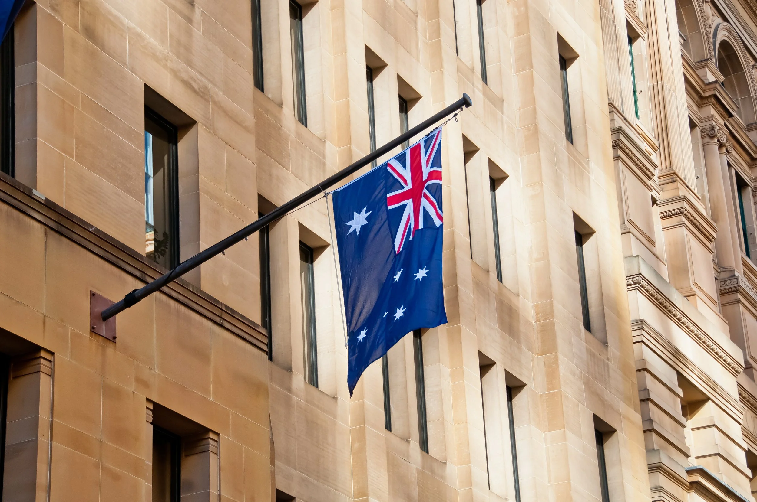 Image of Australian flag hanging from a government building for who we work with government