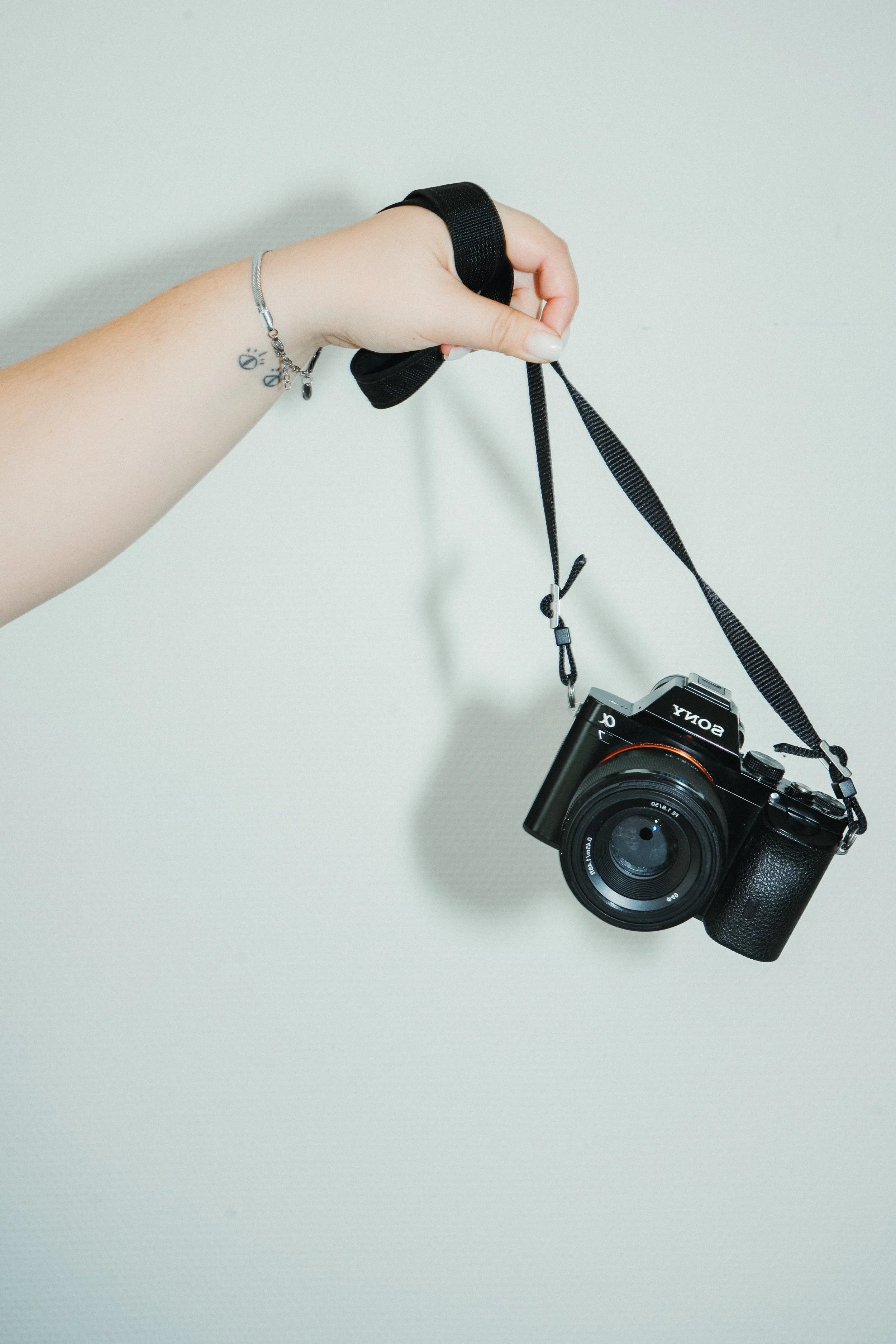 A young woman with curly hair, glasses, and hoop earrings smiling in an indoor setting.