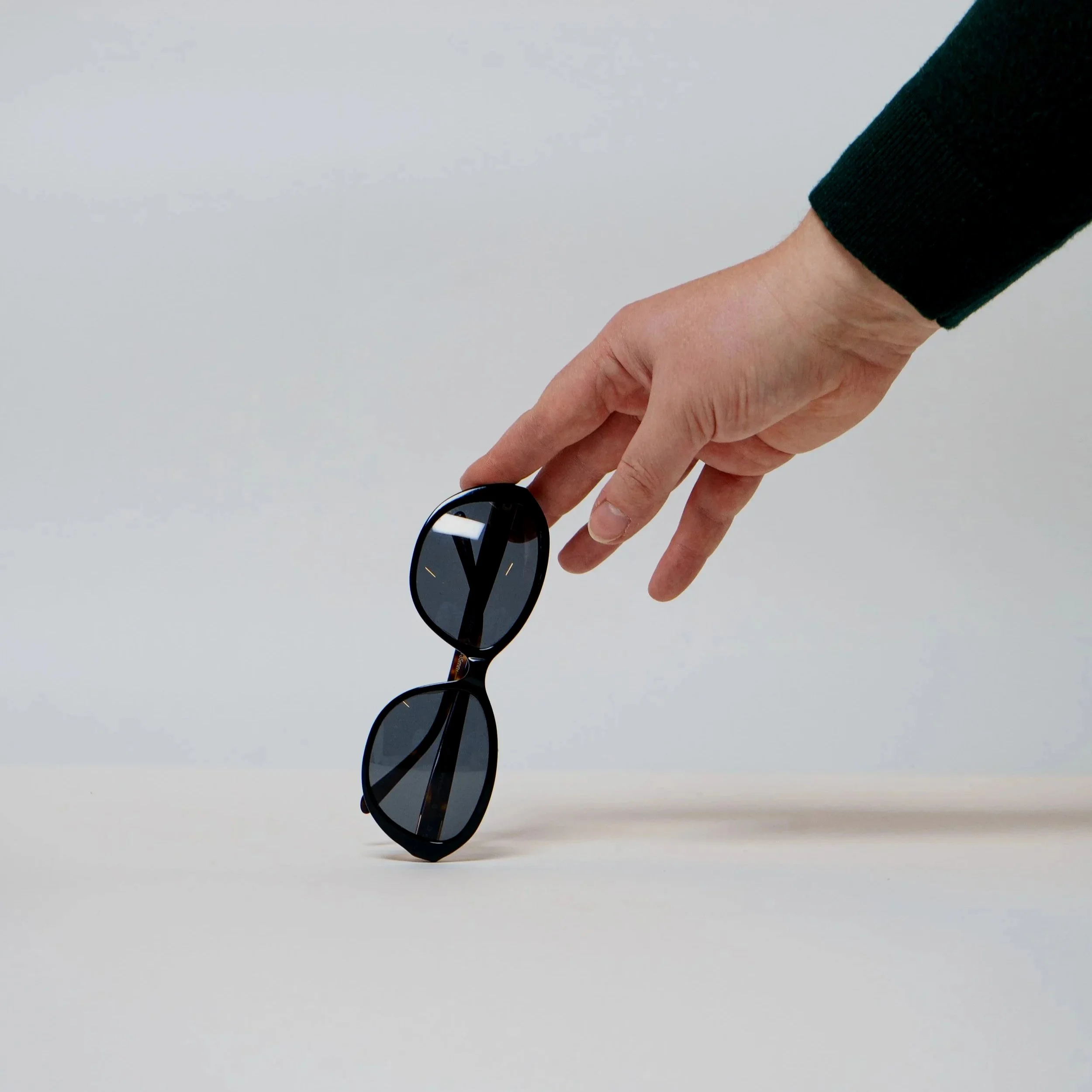 A woman with curly hair and glasses smiling at the camera.