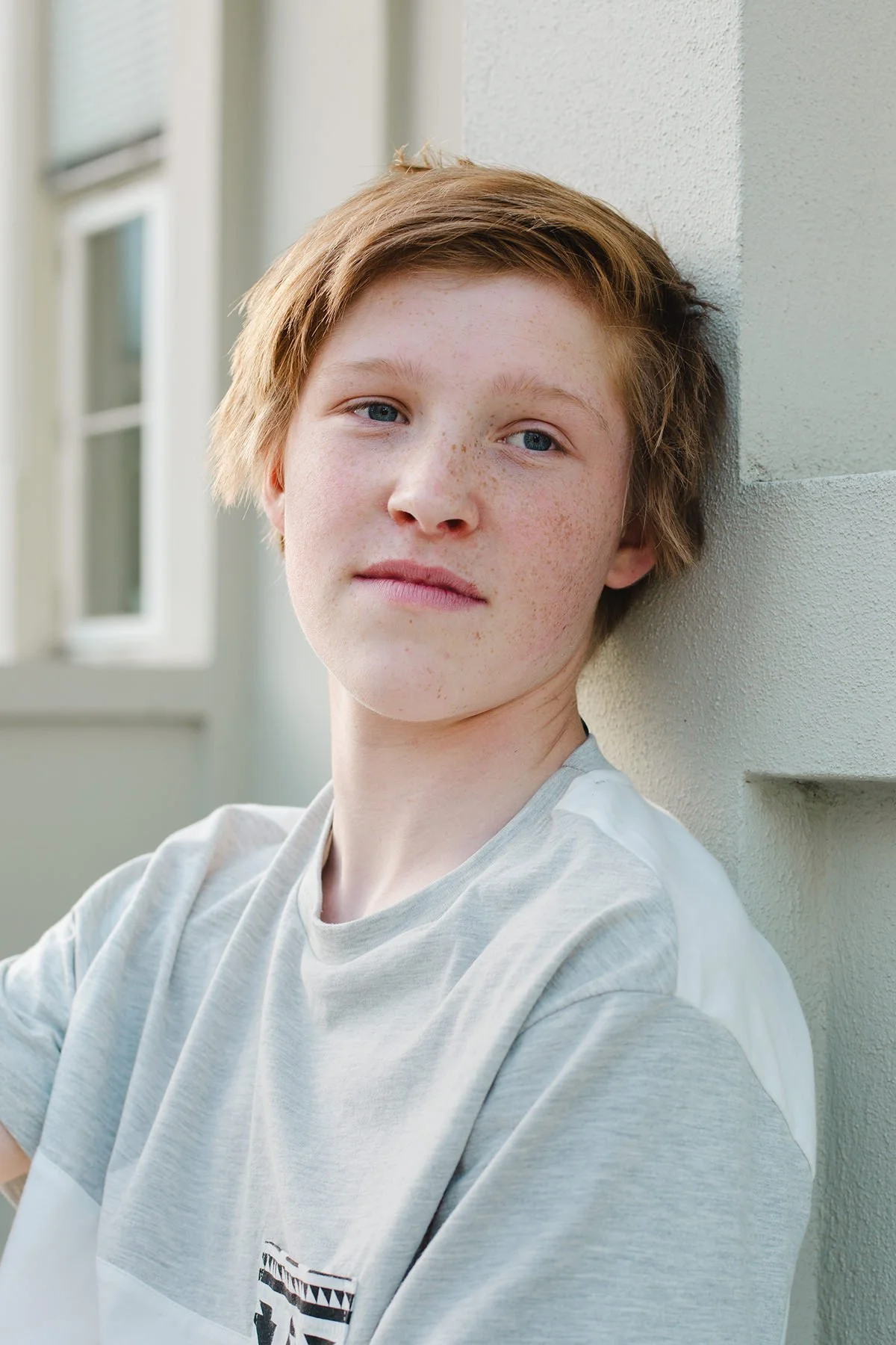 Konfirmantfotografering av gutt. Avslappet portrett i naturlig lys.