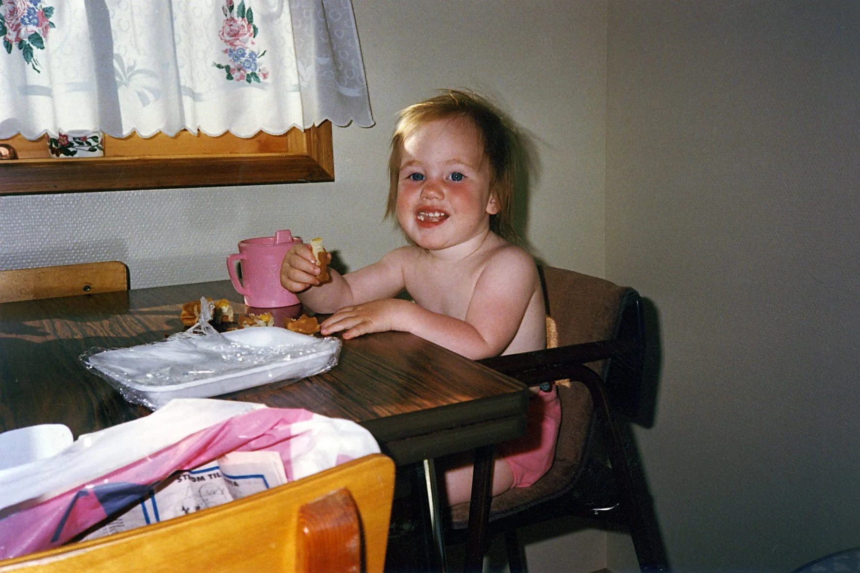 Barn sitter ved bordet og spiser boller.