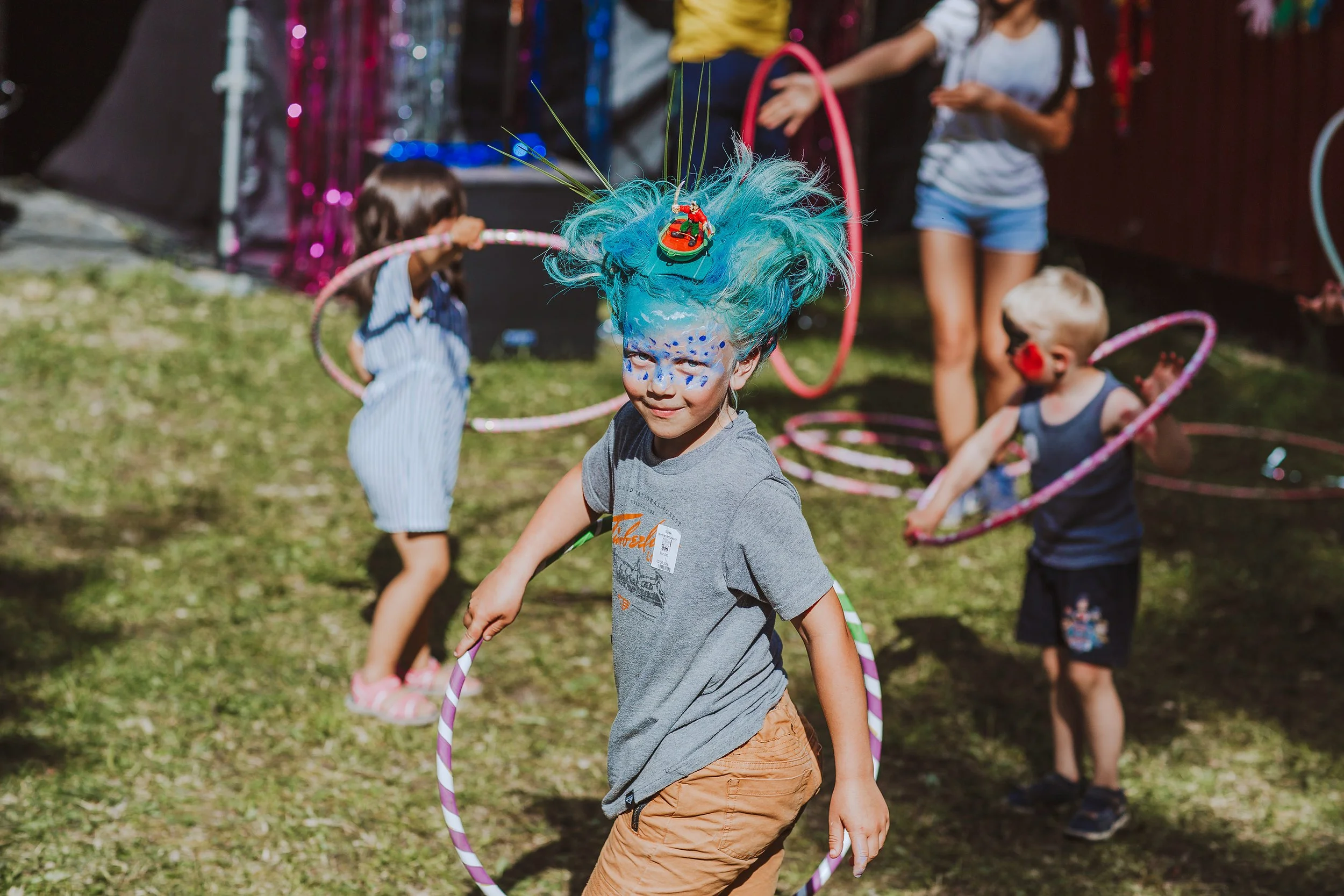 Stoppested Verden internasjonal barnefestival. Gutt med kurativ ansiktsmaling leker med rokkering.