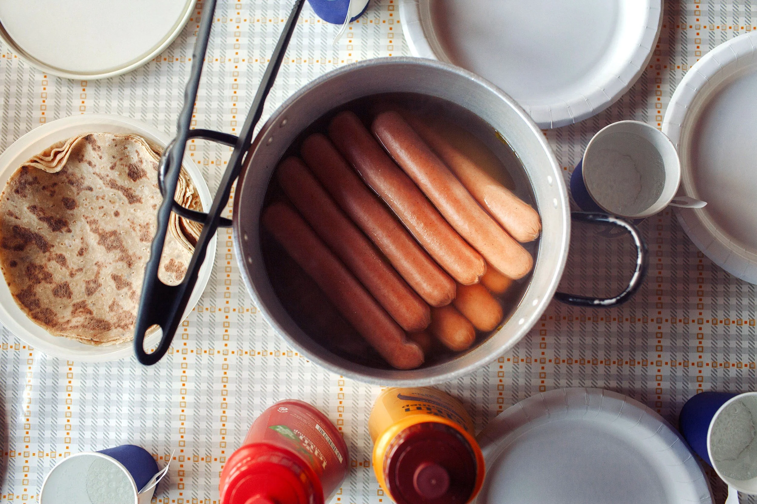 Pølser som trekker i vann i en kjele fotografert i fugleperspektiv.