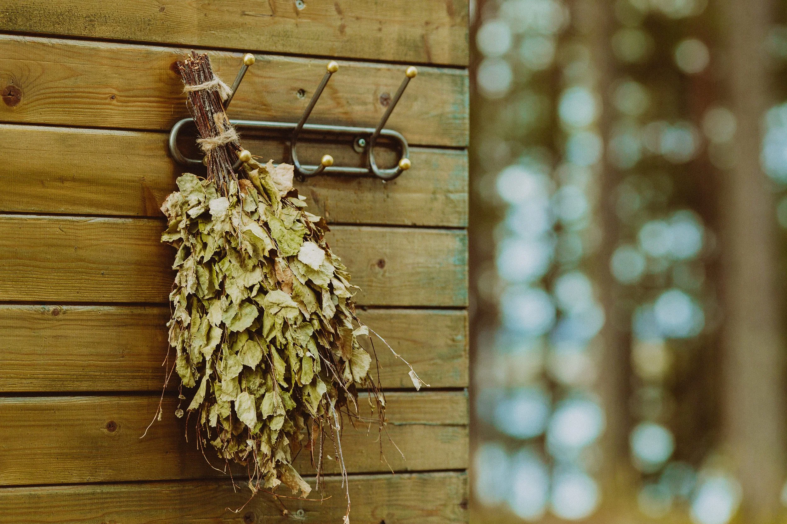 Badstu bjørkeris henger på utsiden av vedfyrt utendørs badstue.