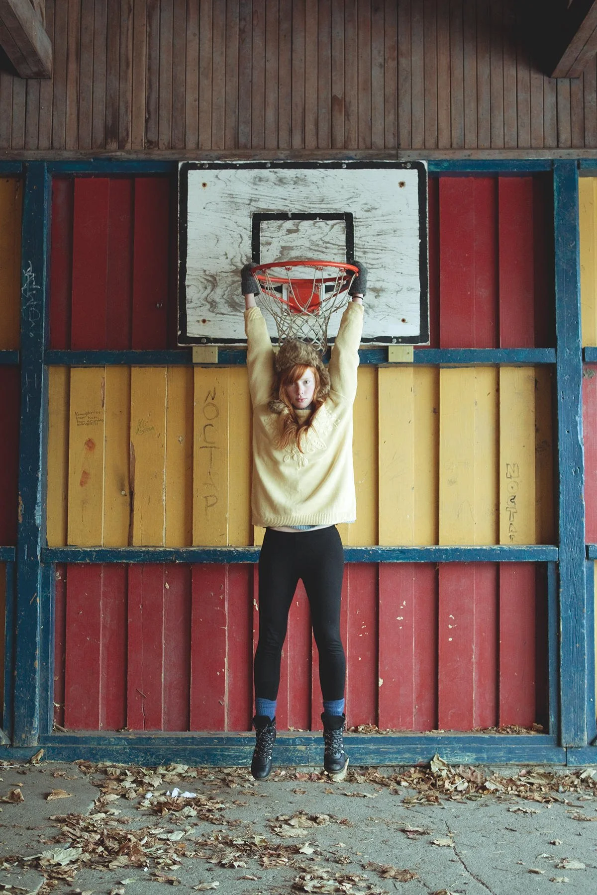 Ung jente hengende med armene fra et basketmål.