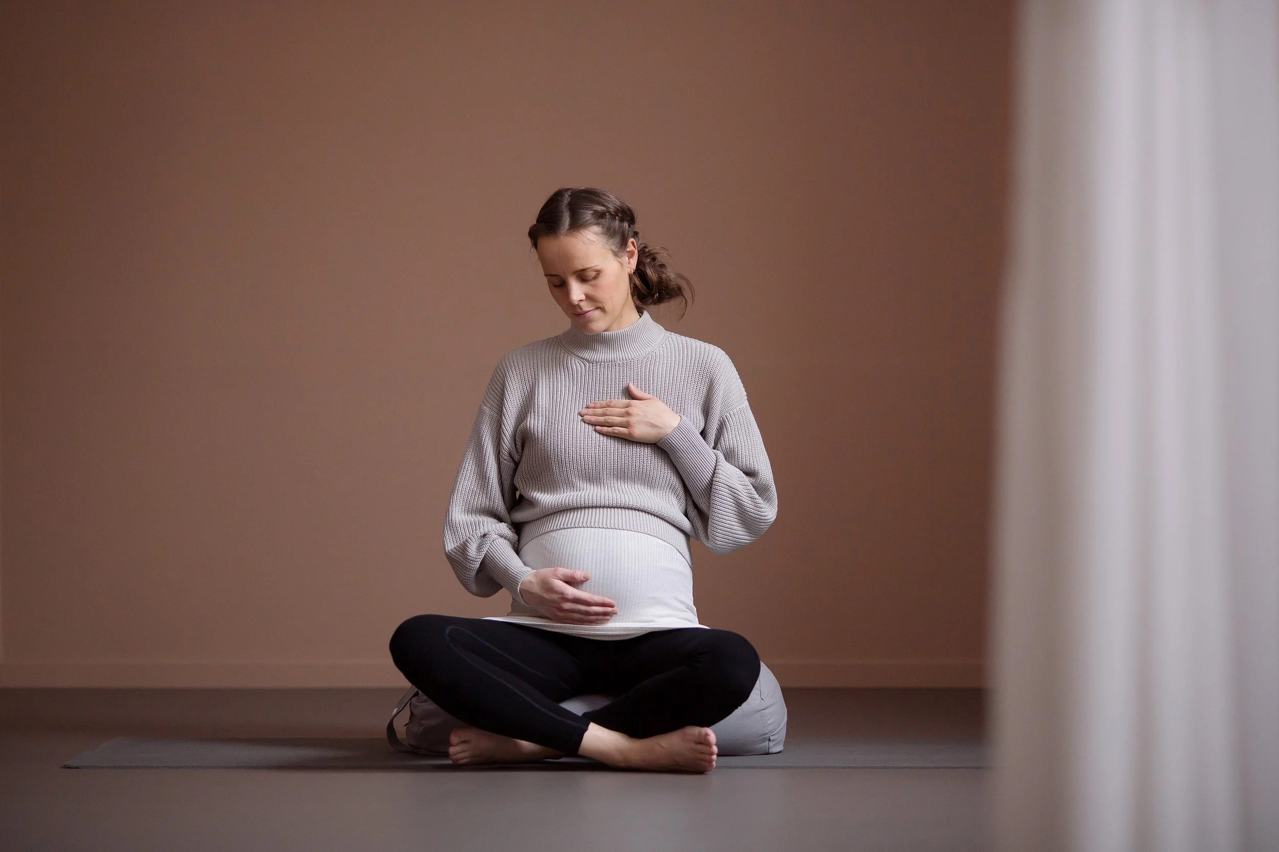 Gravid kvinne i sittende yogapositur.