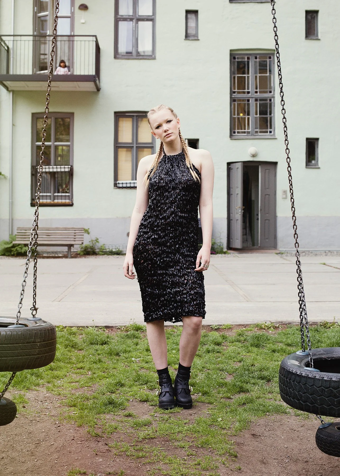 Moteportrett av kvinne i kjole i en bakgård.