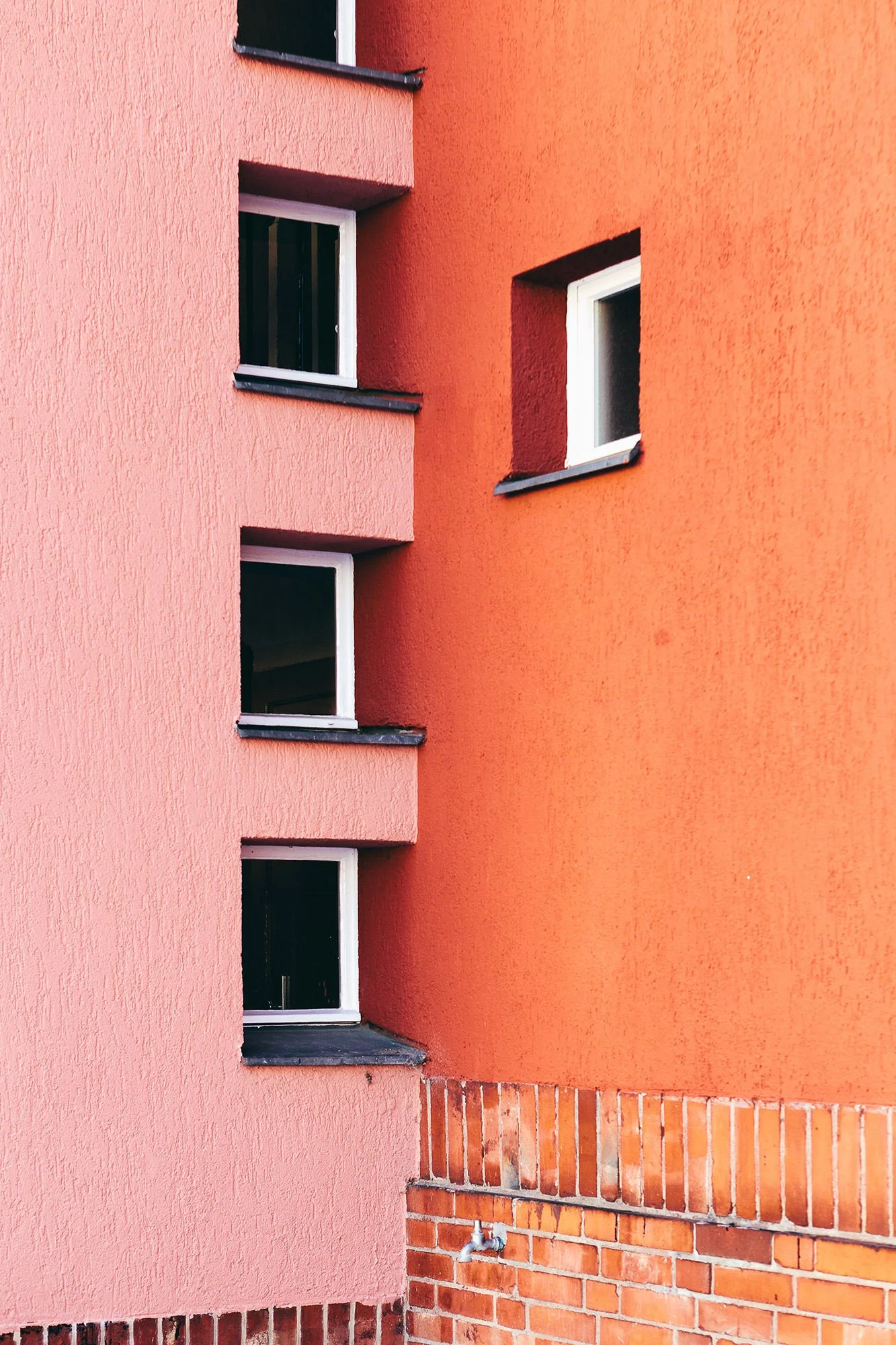 Utsnitt av rosa og rød murvegg som møtes.