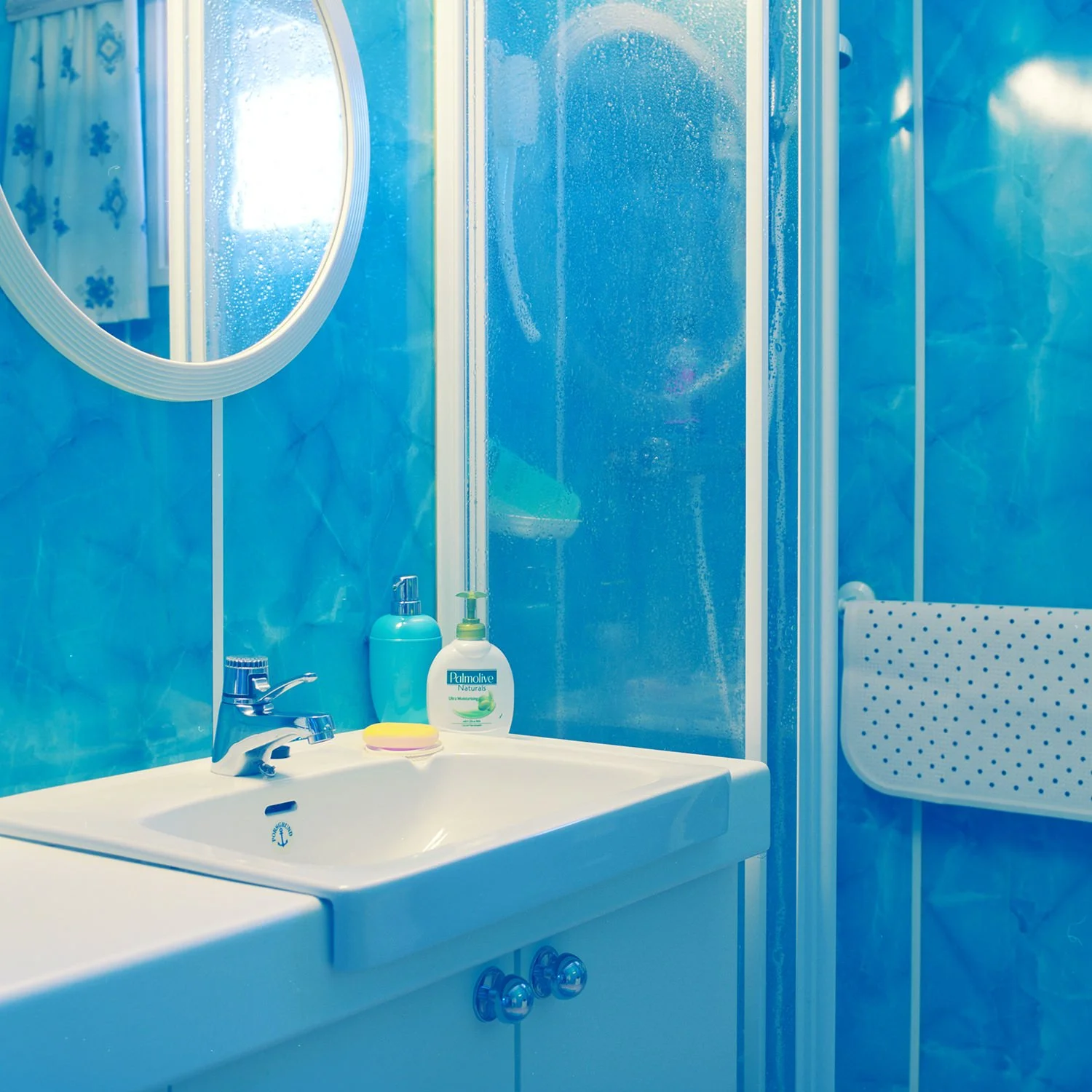 Utsnitt av interiør på bad med blå vegger.