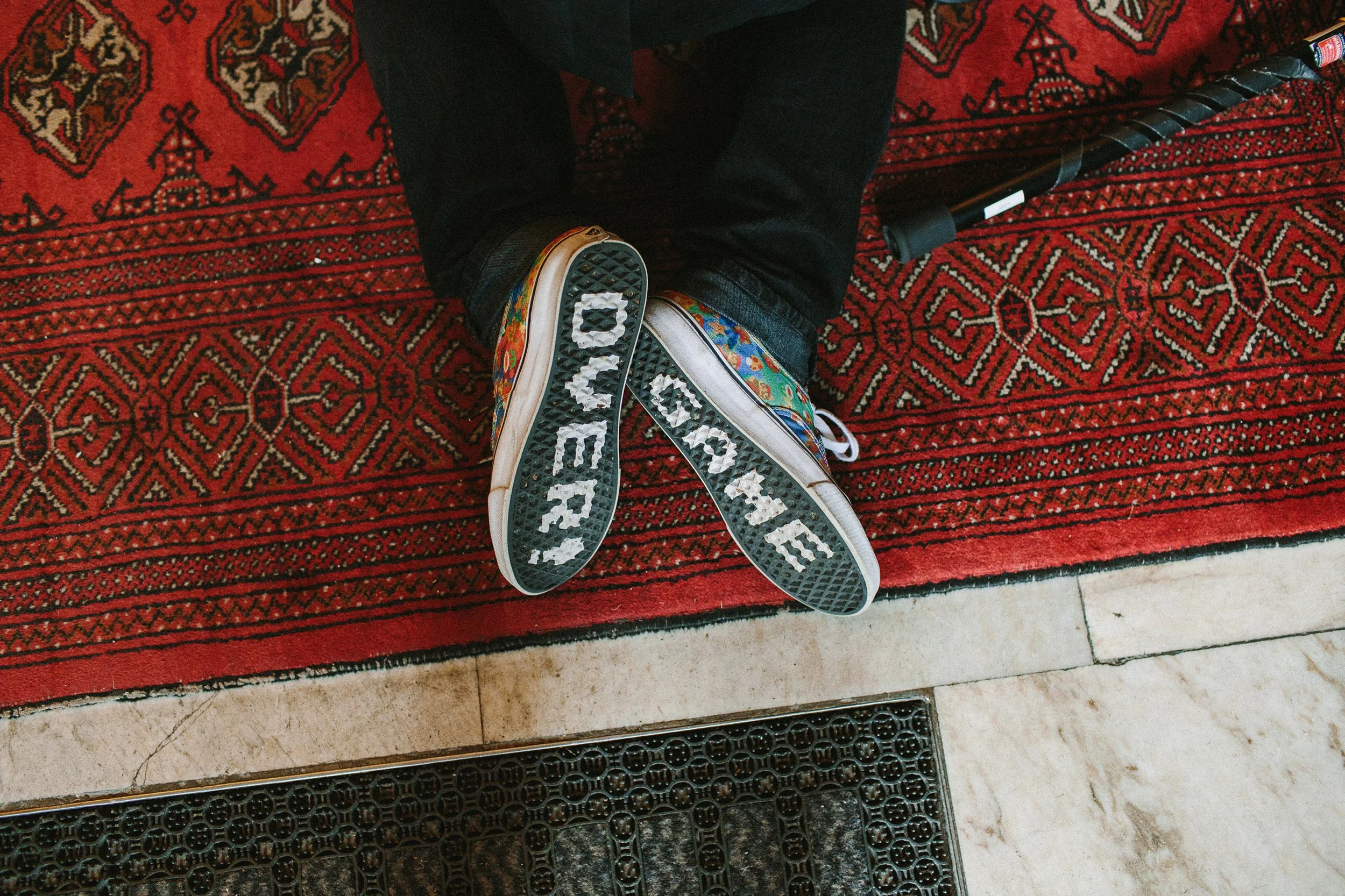 En person sitter på kne. På undersiden av skoene står teksten "Game over"