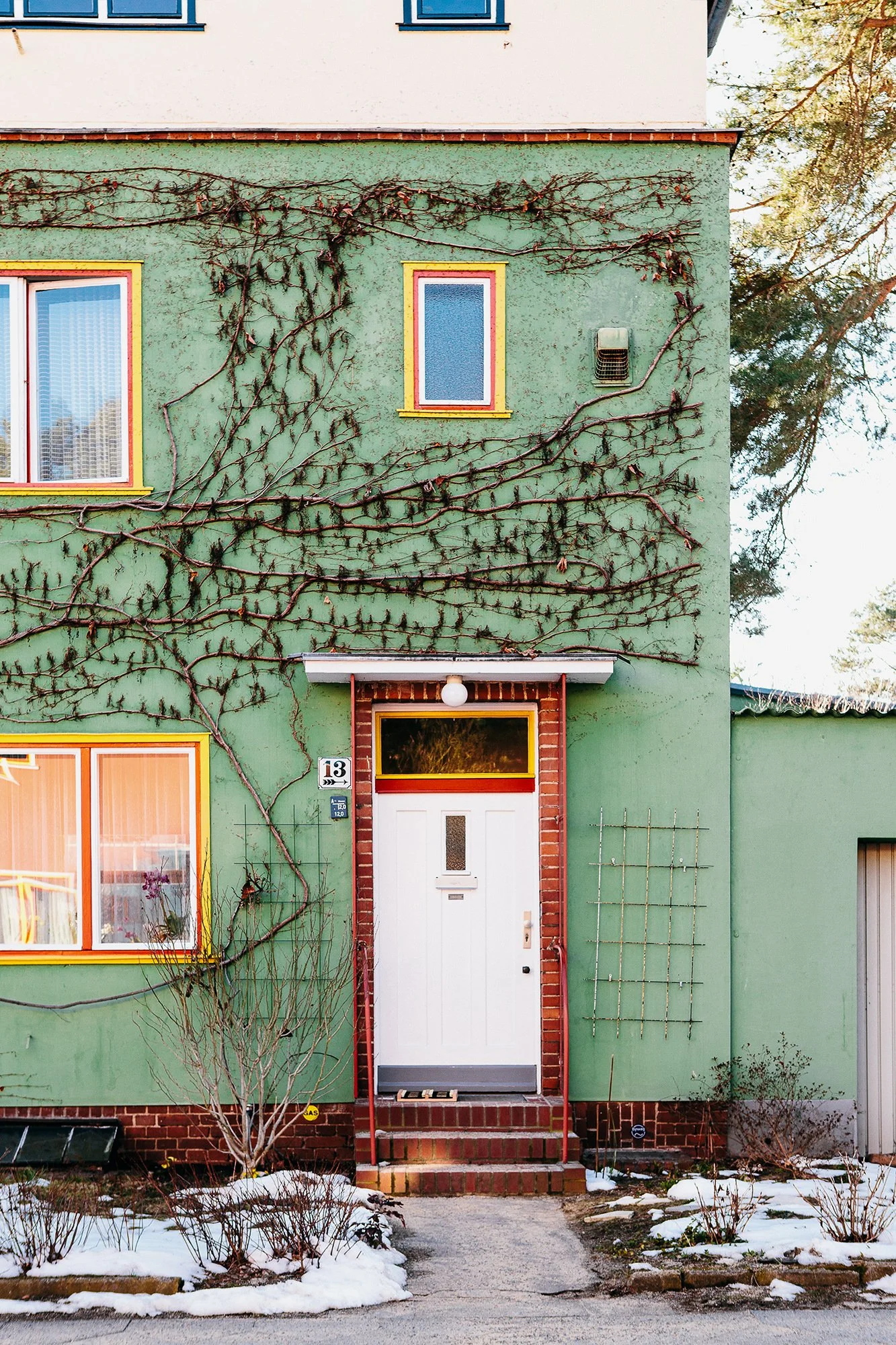 Boligfelt i Onkel Toms Hütte i Berlin, tegnet av arkitekt Bruno Taut. Grønt murhus med klatreplanter som slynger seg opp veggen.