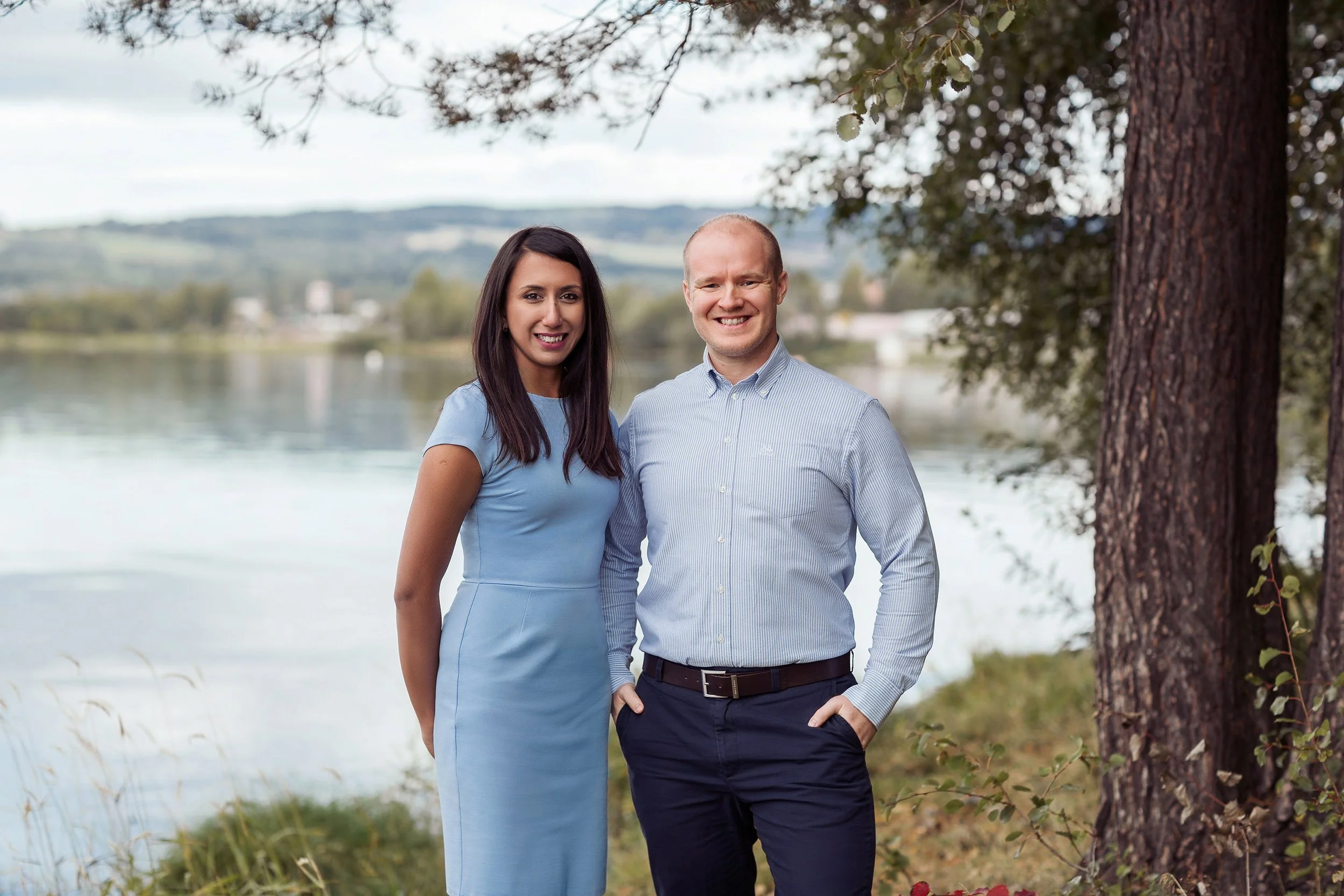 Profesjonelt bedriftsportrett utendørs av kvinne og mann ved Mjøsa.