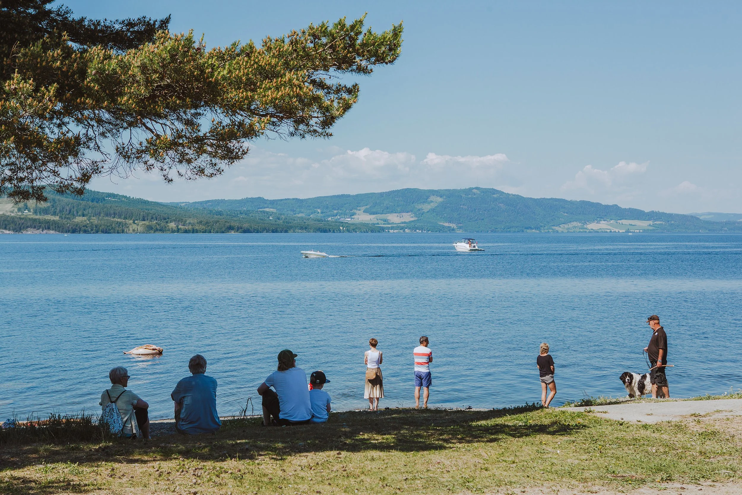 Mennesker som slapper av ved Mjøsa på sommeren.