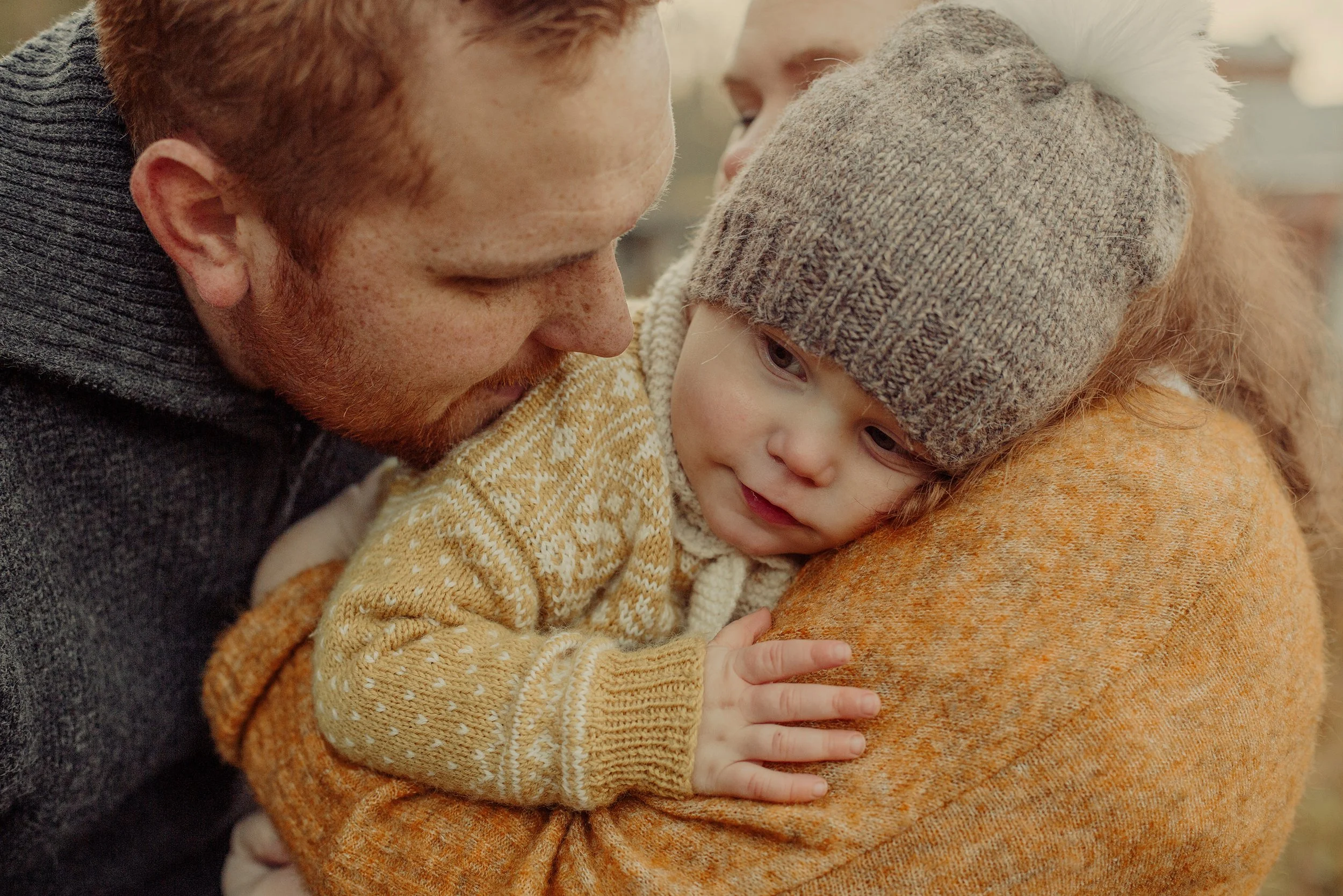 Liten gutt hviler seg mot skulderen til sin mor på familiefotografering.