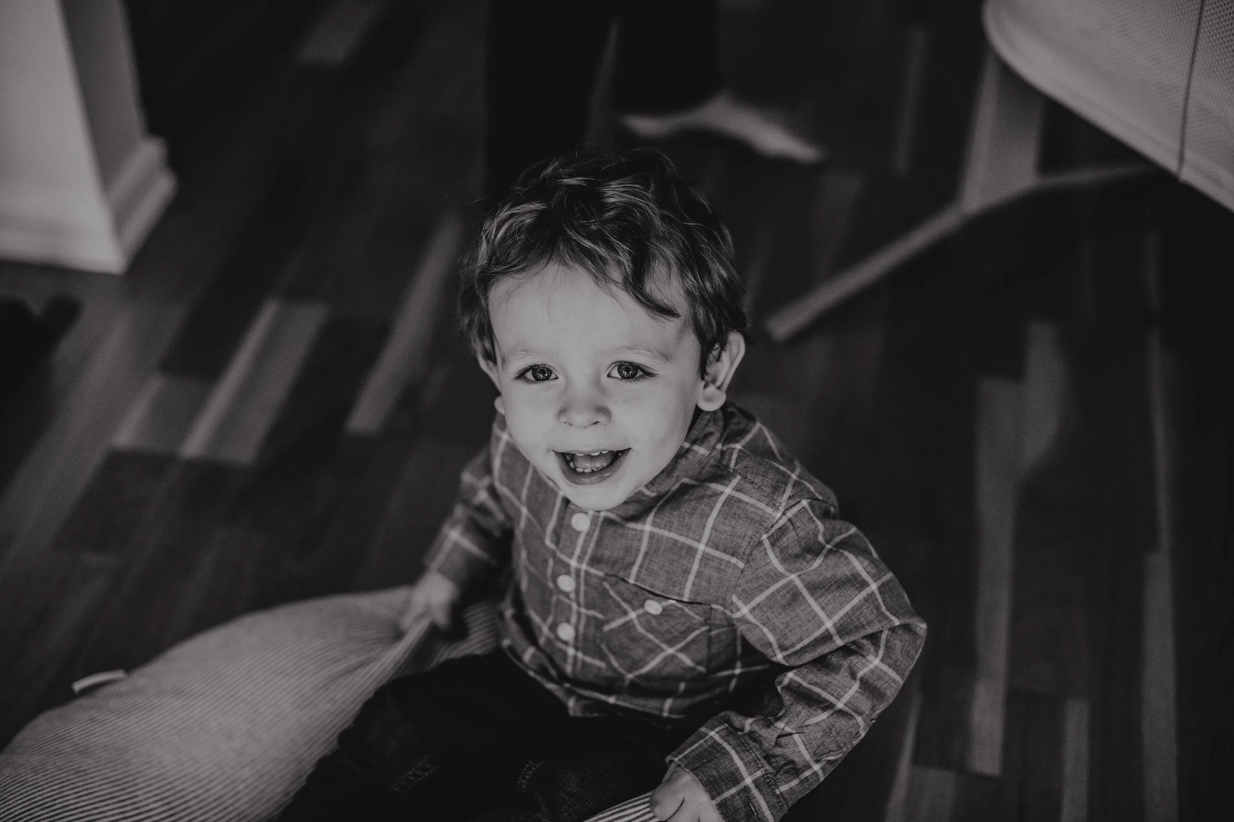 Søsken leker på gulvet på nyfødtfotografering hjemme.