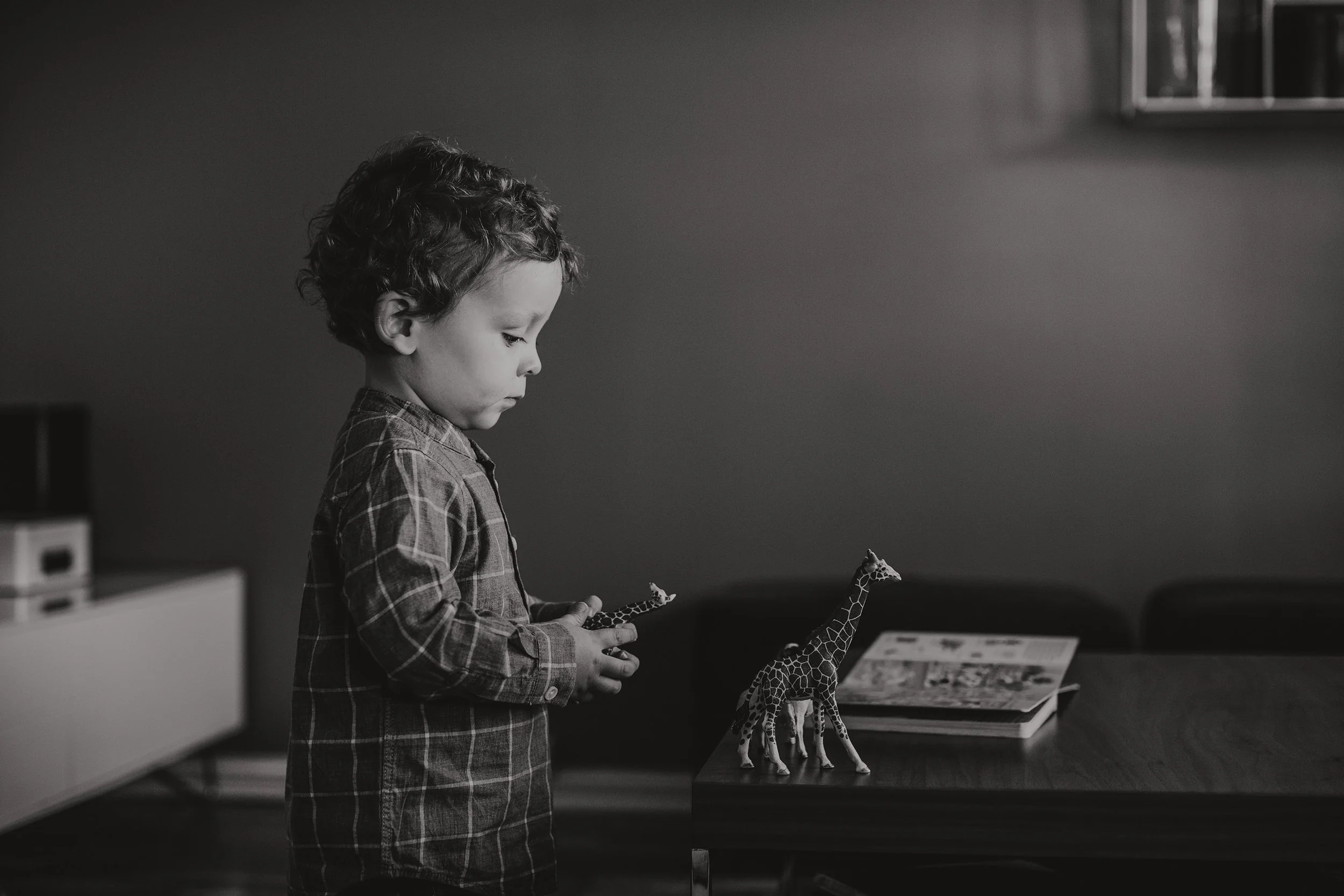 Barn leker med dyrefigurer på stuebordet