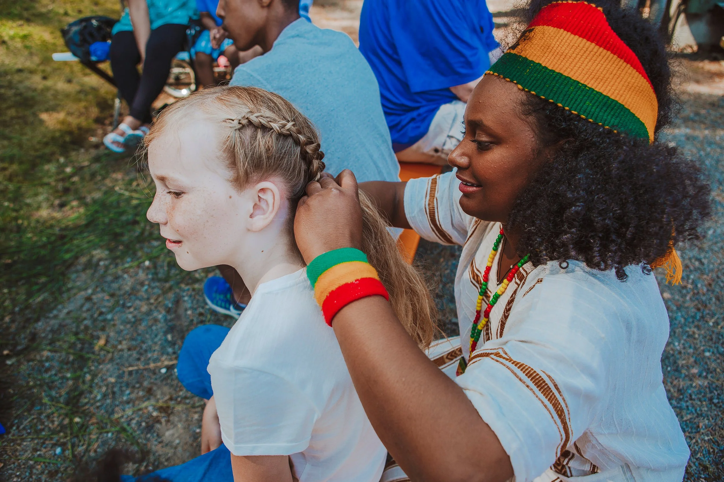 Stoppested Verden internasjonal barnefestival. Jente får håret flettet.