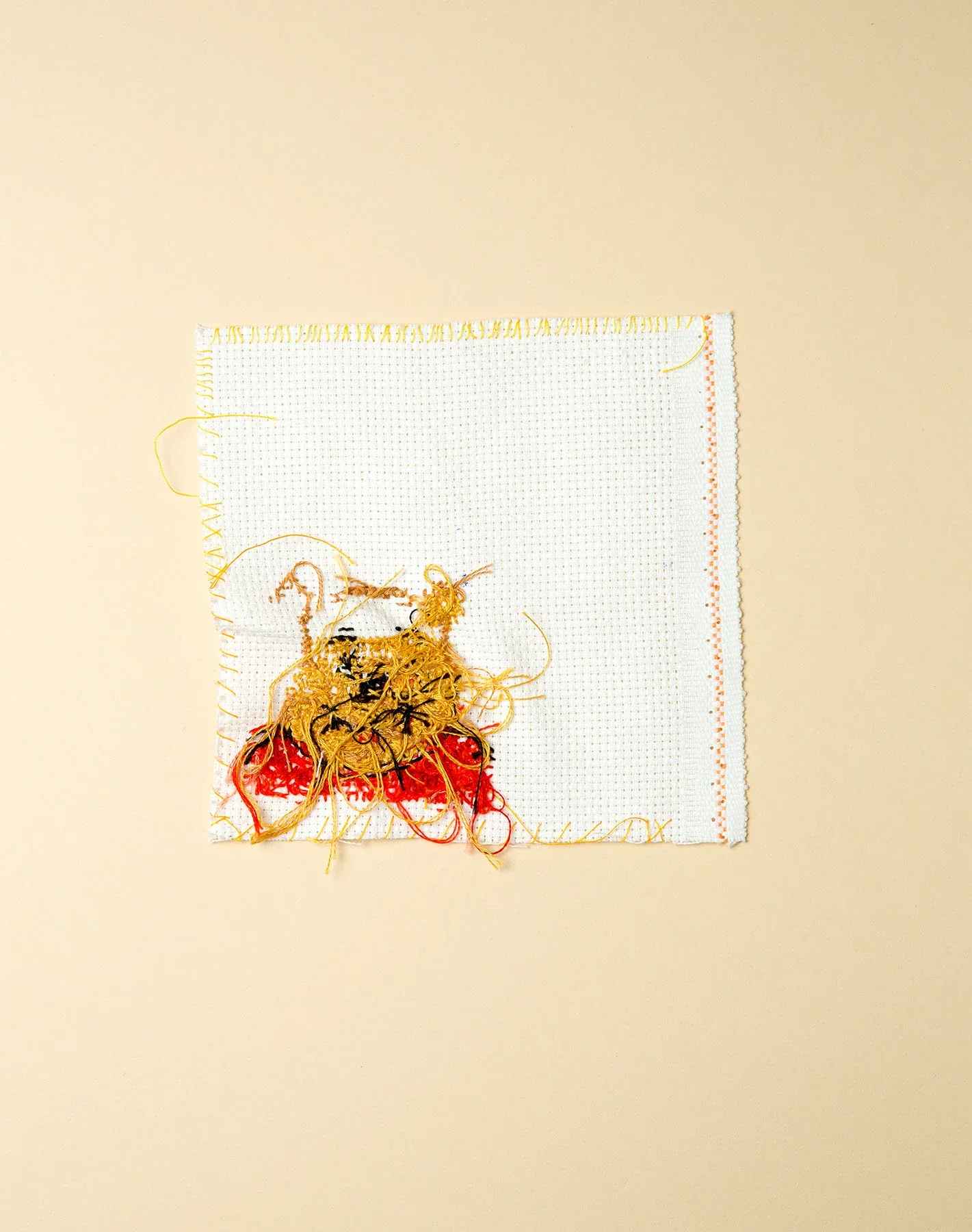 Baksiden av et broderi med motiv av Ole Brum.