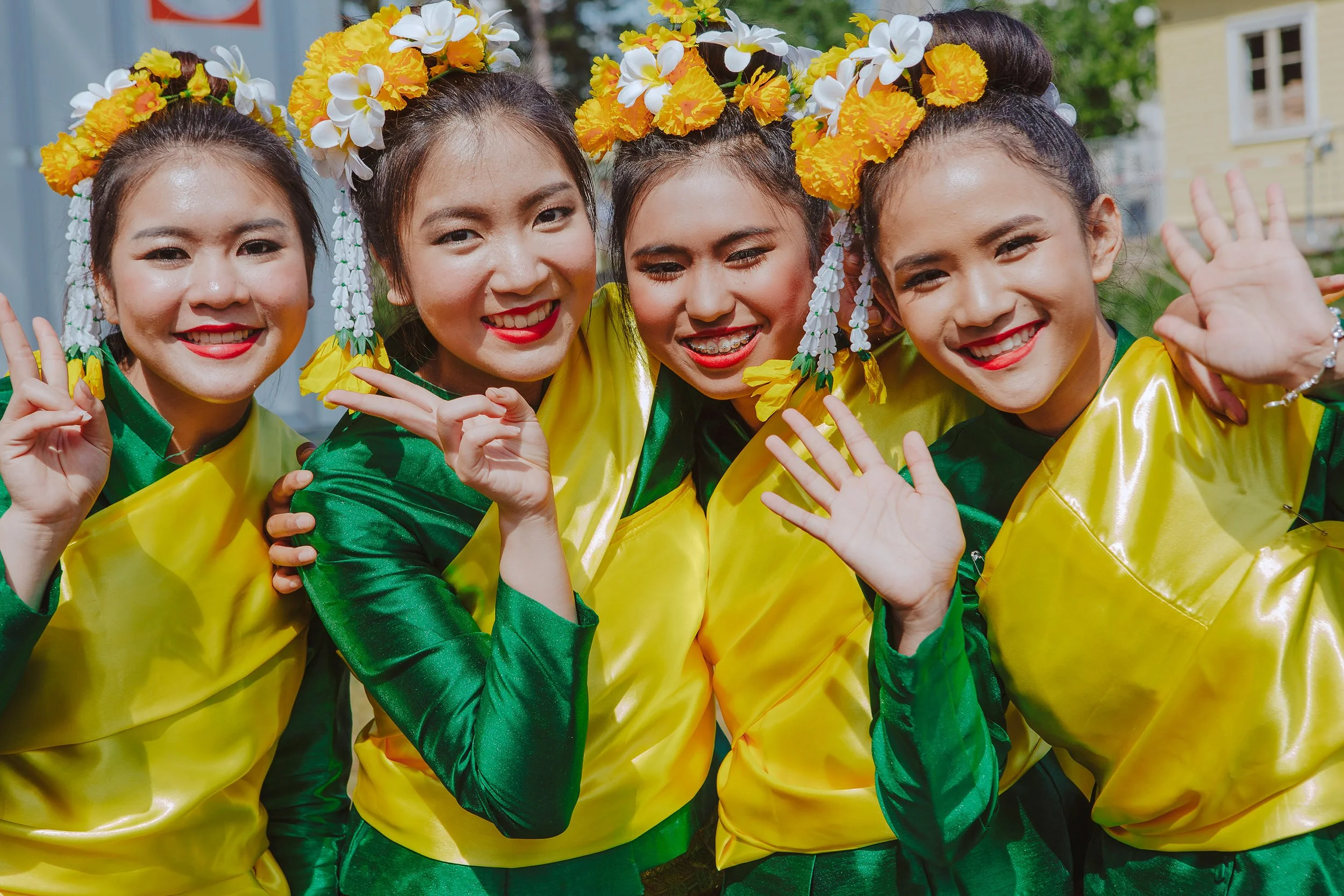 Stoppested Verden internasjonal barnefestival. Fire glade jenter i asiatiske drakter smiler før de skal på scenen og opptre.