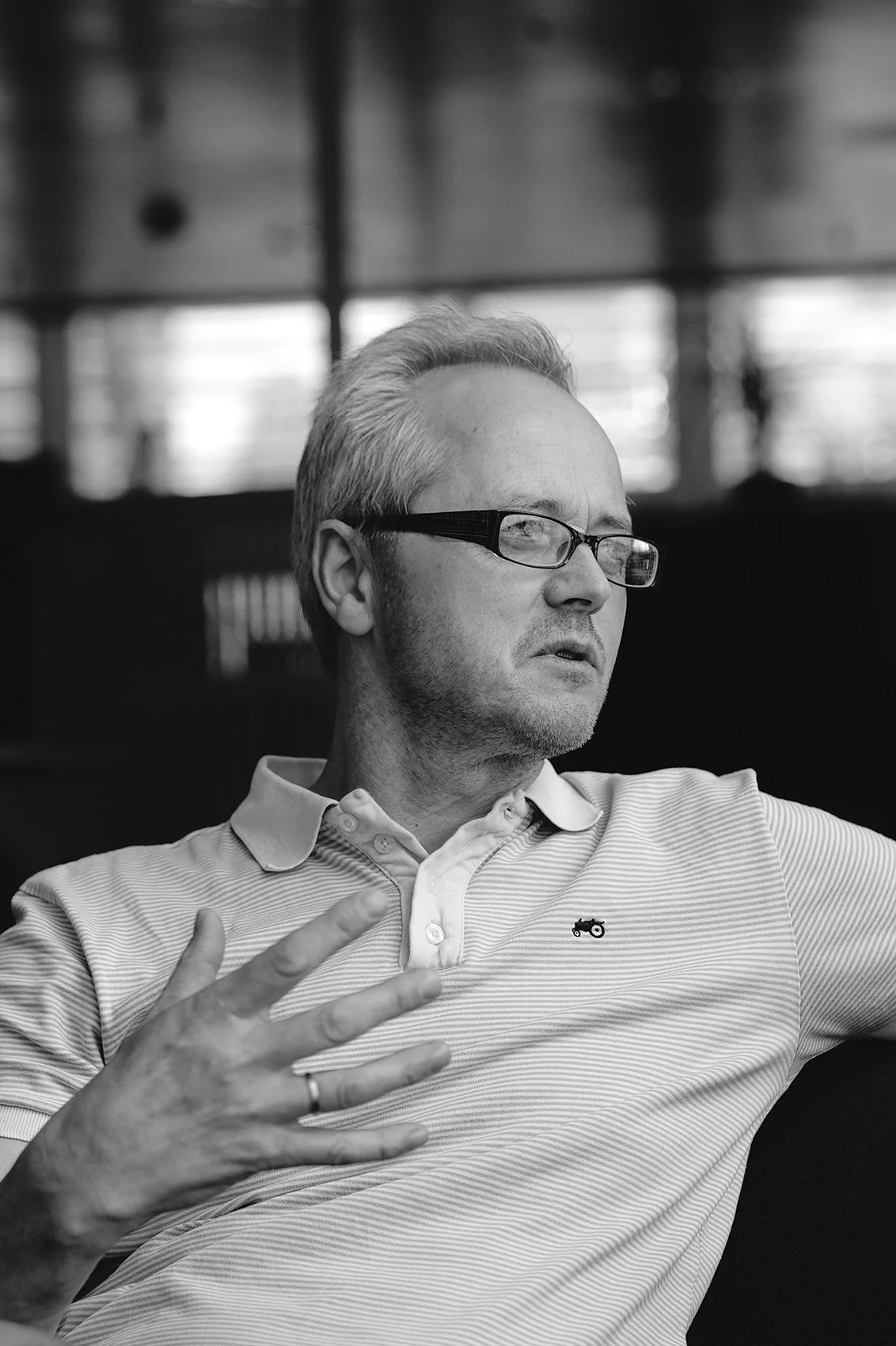 Redaksjonelt portrett av mann som snakker mens han gestikulerer med hendene.